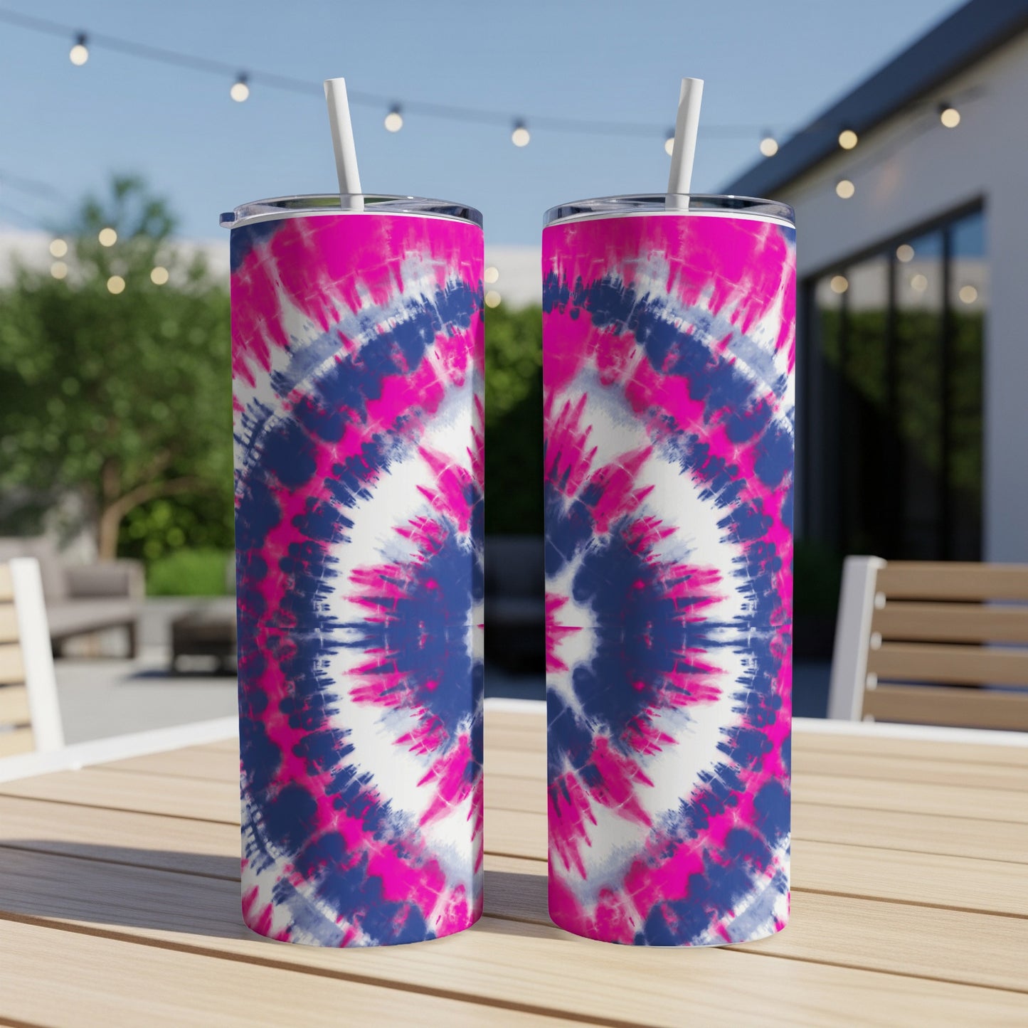 Two tumblers with pink, white, and blue tie-dye pattern and white straws on table.