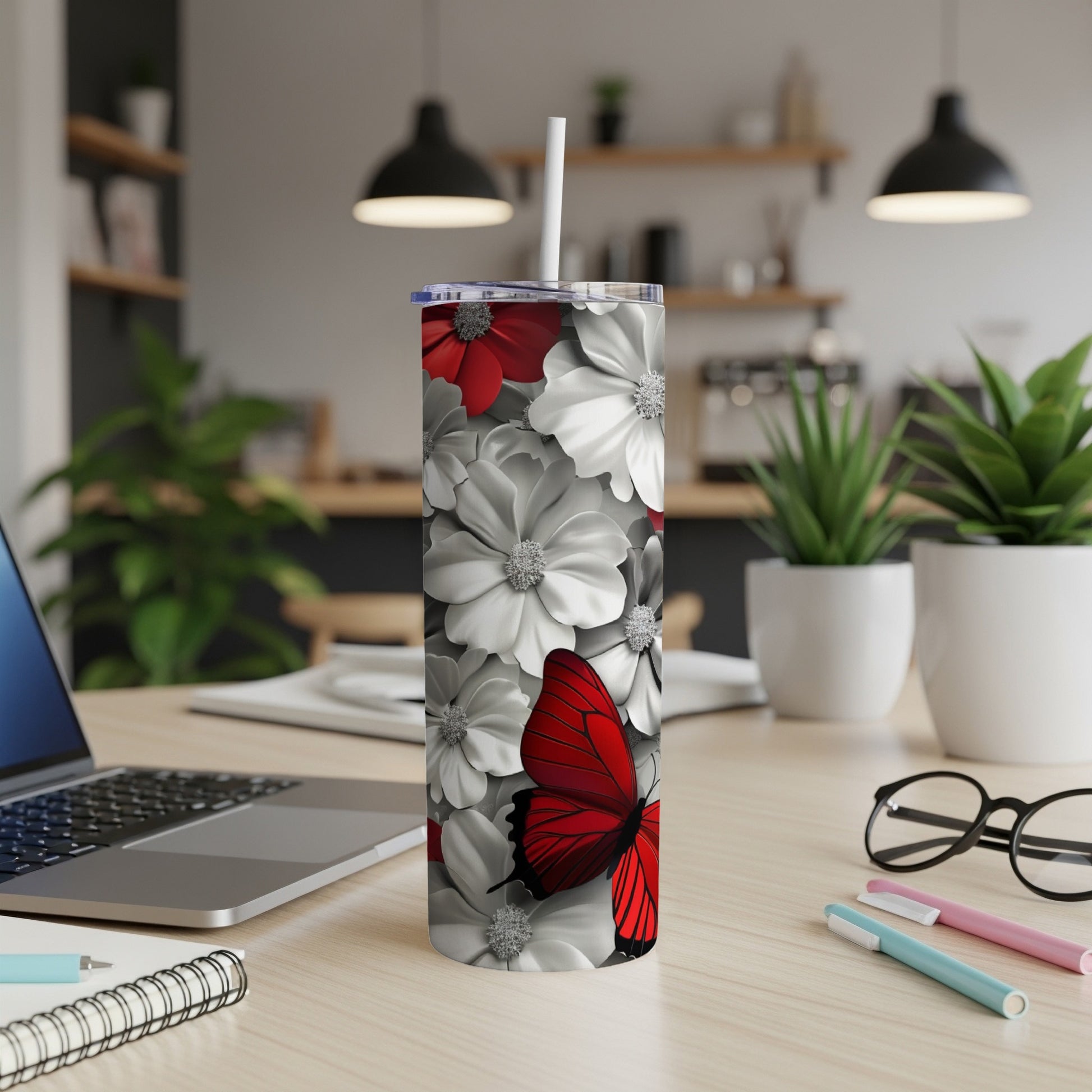 Red butterfly and white flowers on a tall tumbler with a straw.