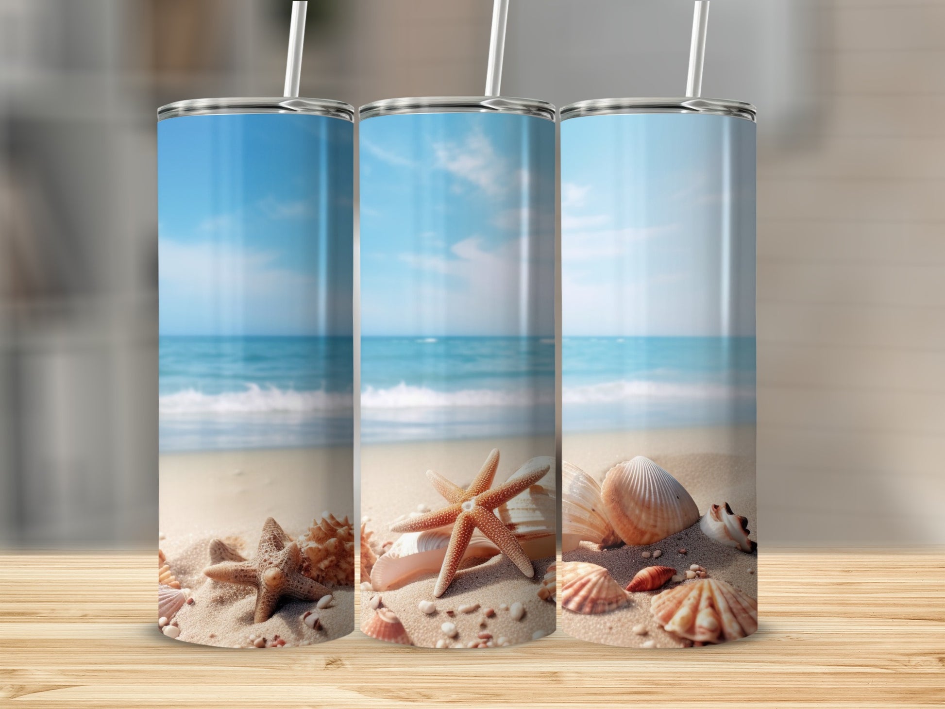 Three beach-themed tumblers with starfish and shells on sand.
