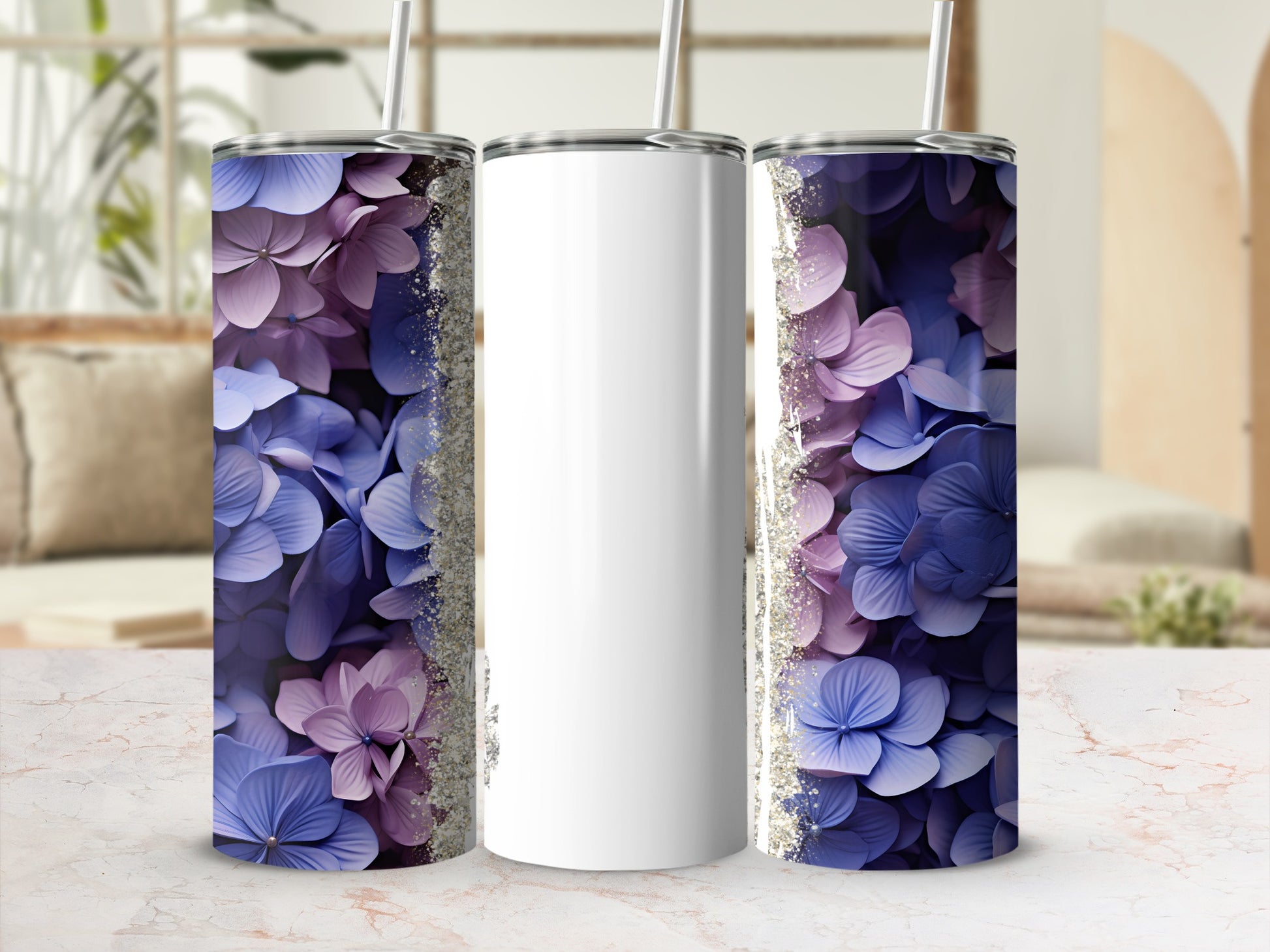 Two tumblers with purple and blue floral designs flanking a blank white tumbler.