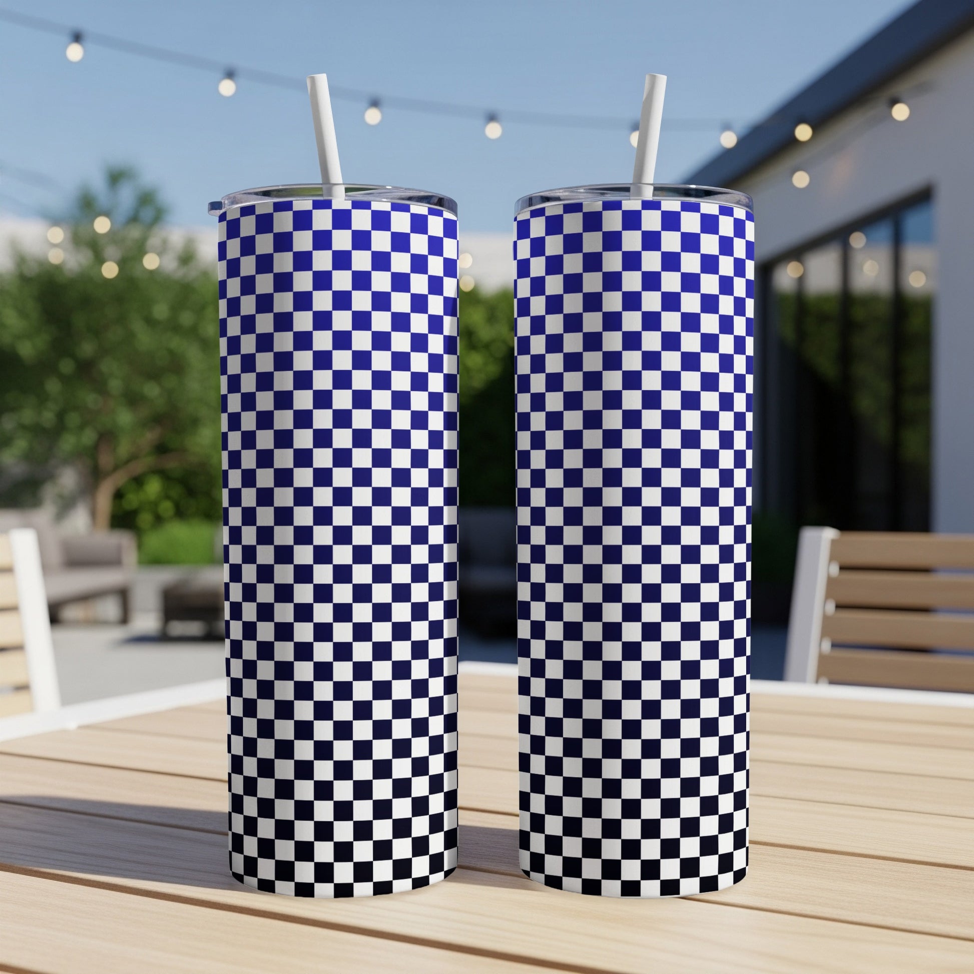 Two tall tumblers with blue and white checkered pattern and straws.