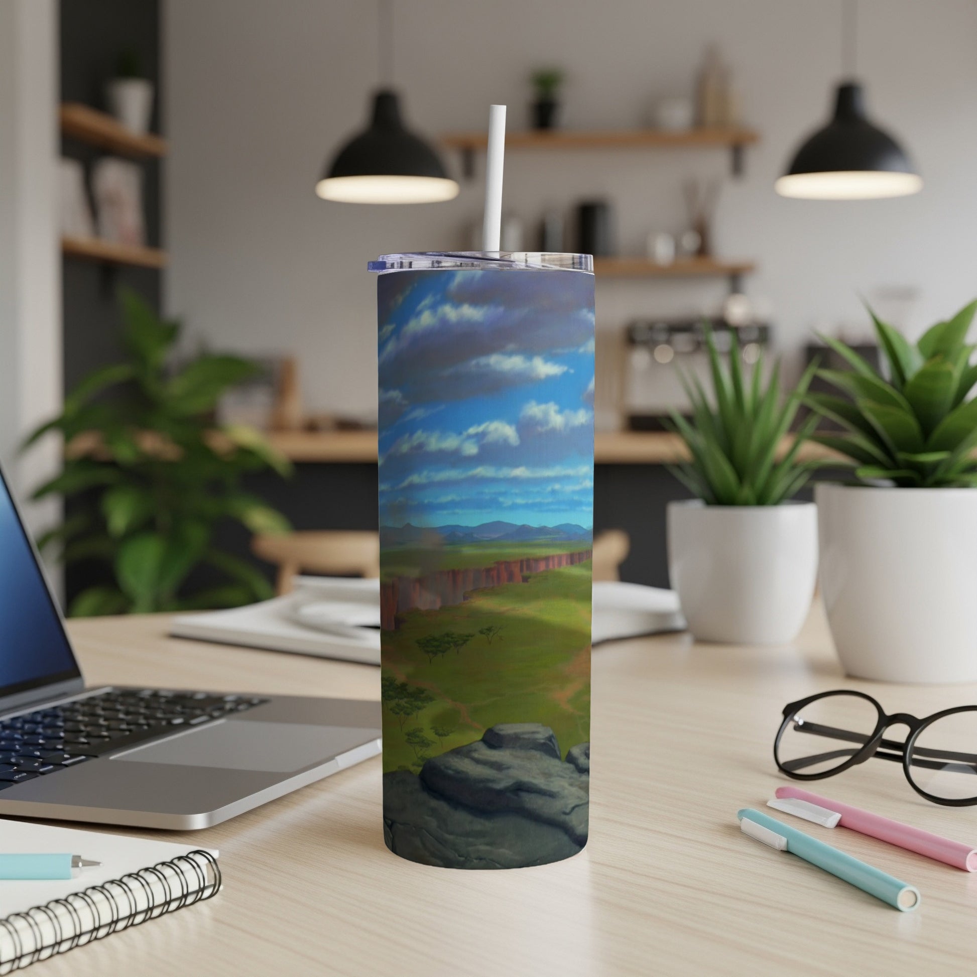 Tumbler with a landscape scene of a canyon under a cloudy blue sky.