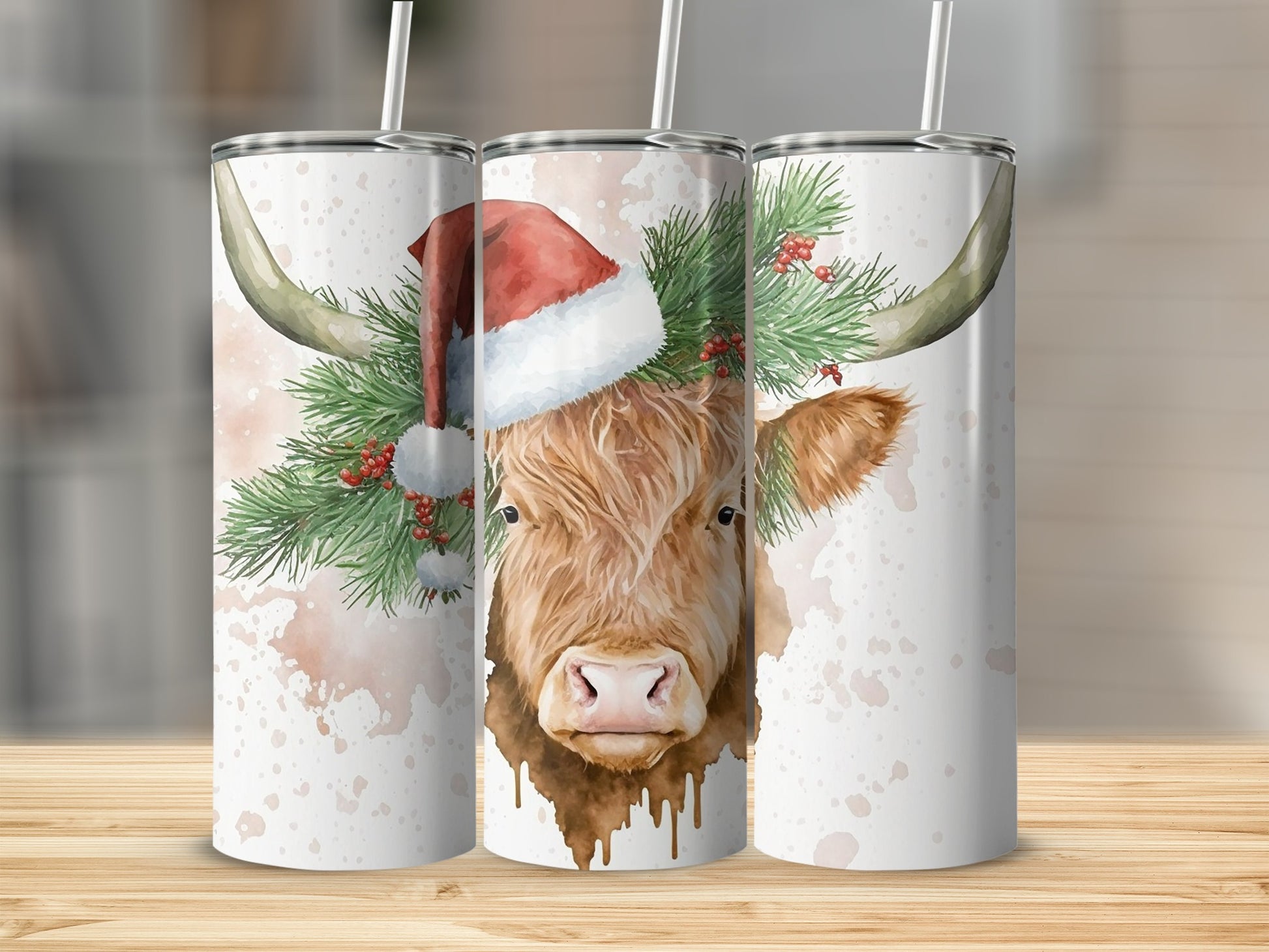 Highland cow wearing Santa hat with pine needles, three tumblers.