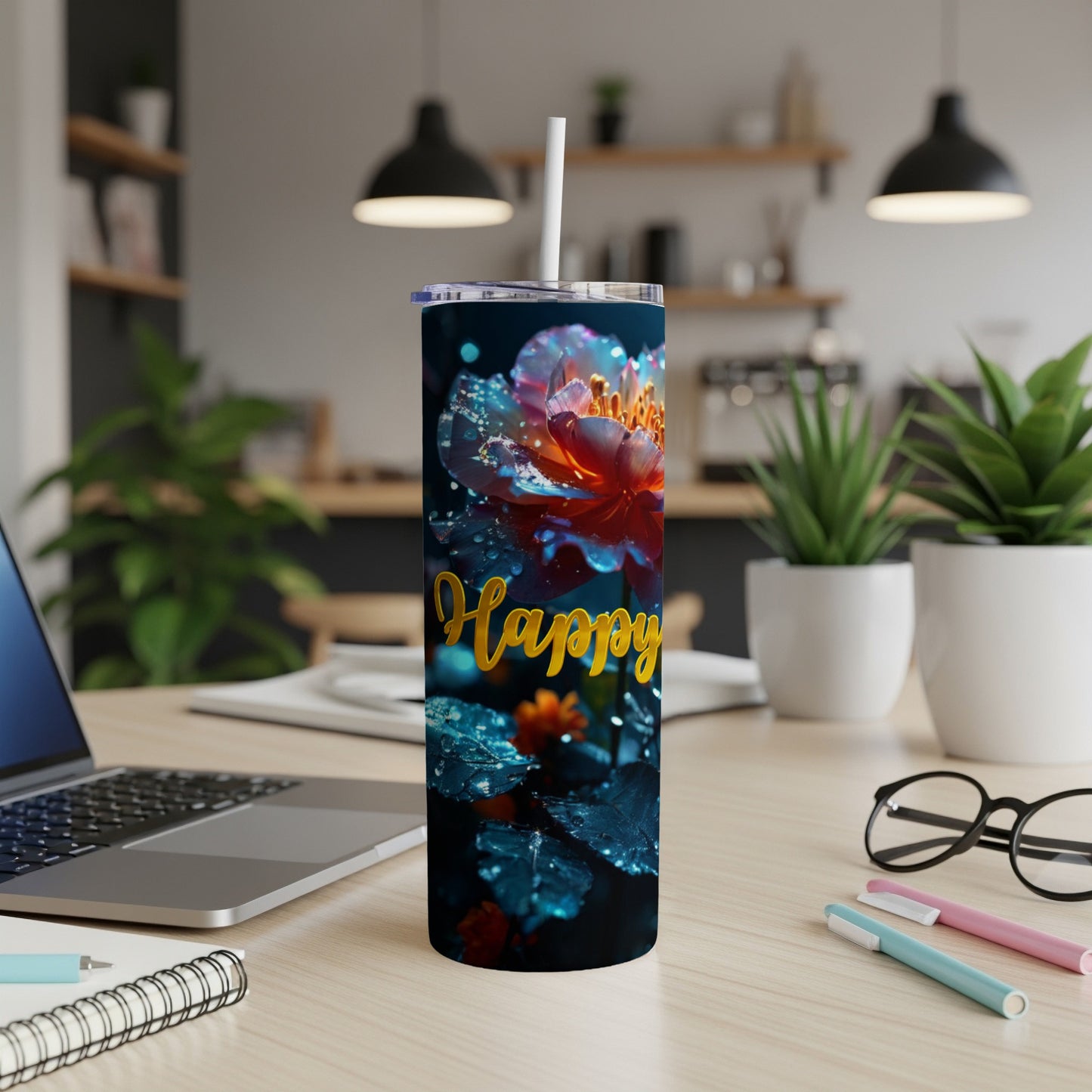 Floral tumbler with "Happy" text and a straw, on a desk.