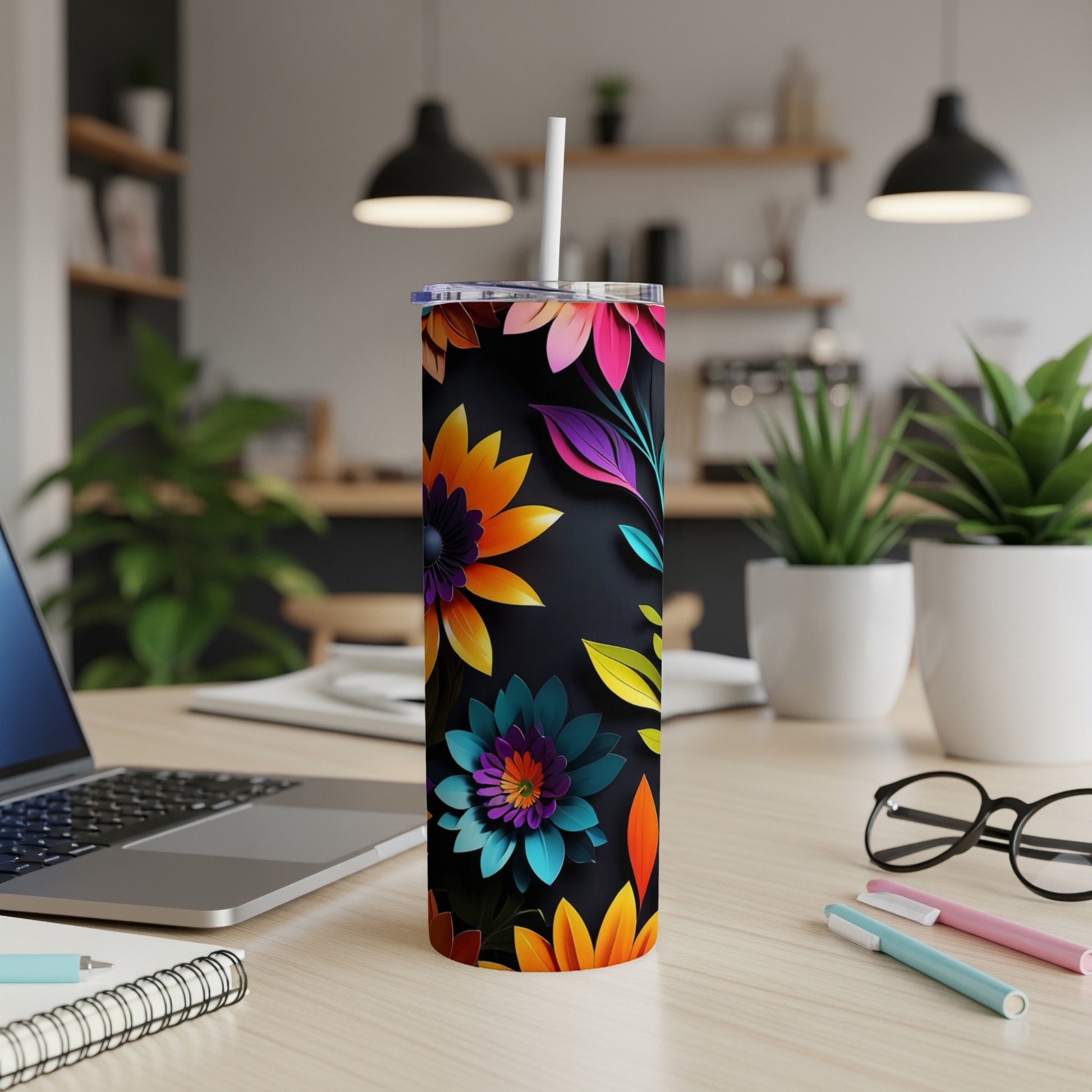 Black tumbler with colorful floral and leaf pattern, white straw.