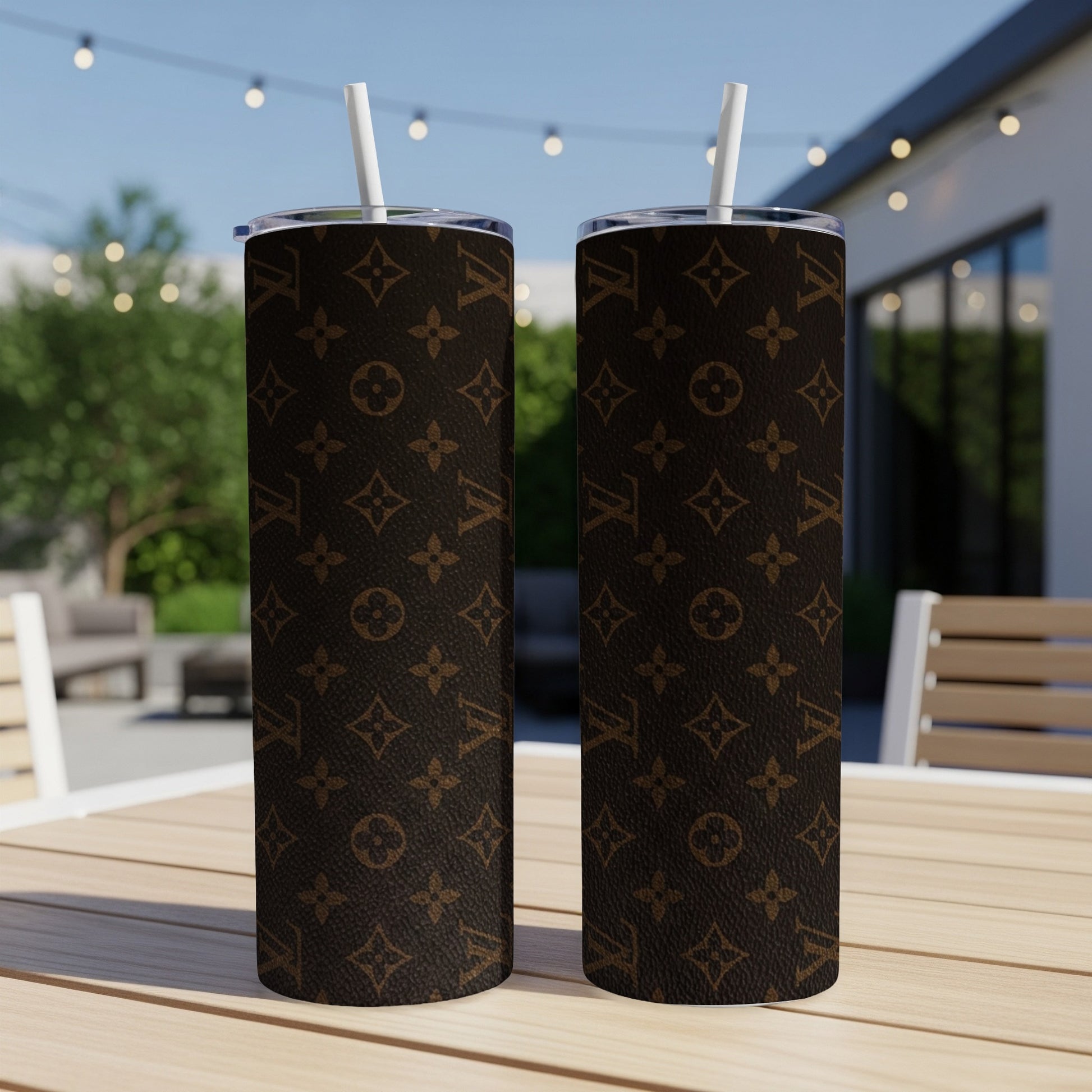 Two brown tumblers with LV monogram pattern on a table.