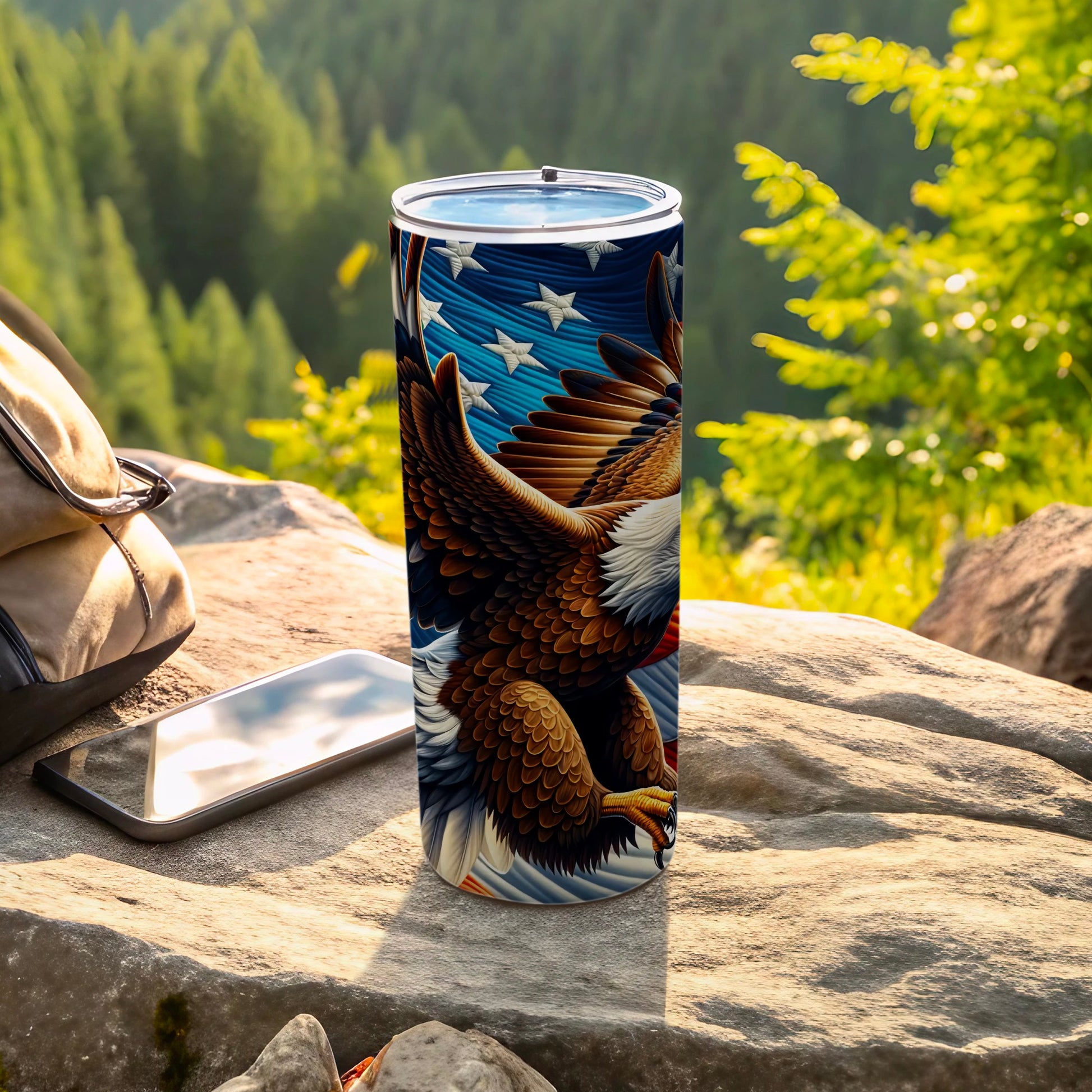 American eagle flag design on a stainless steel tumbler on a rock.