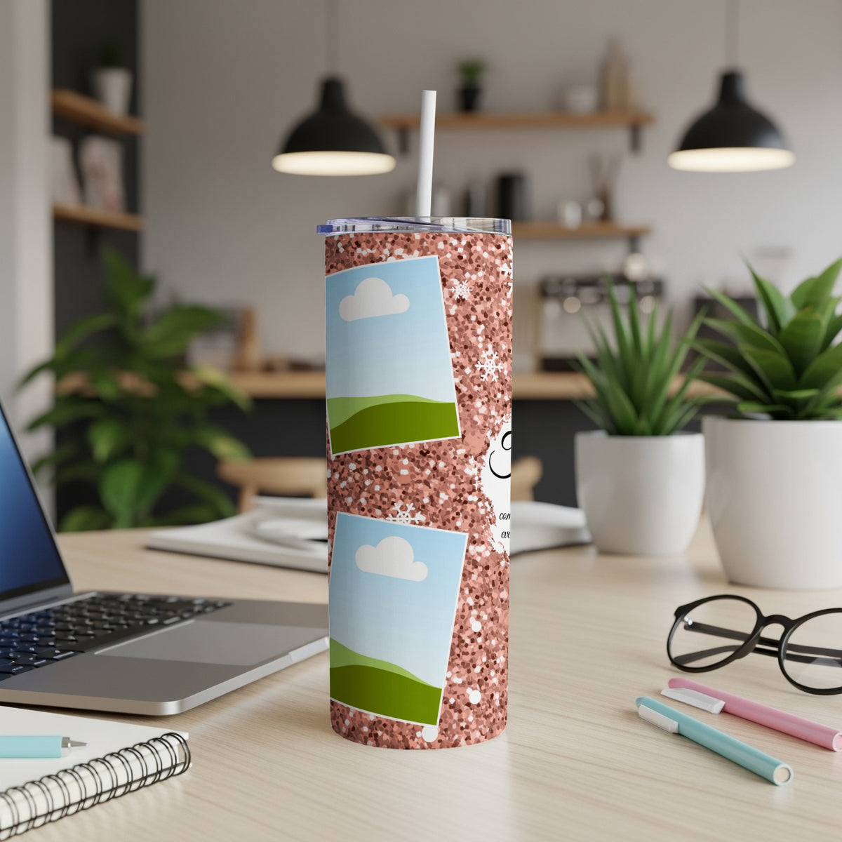 Glitter tumbler with two photo frames and a straw on a desk.