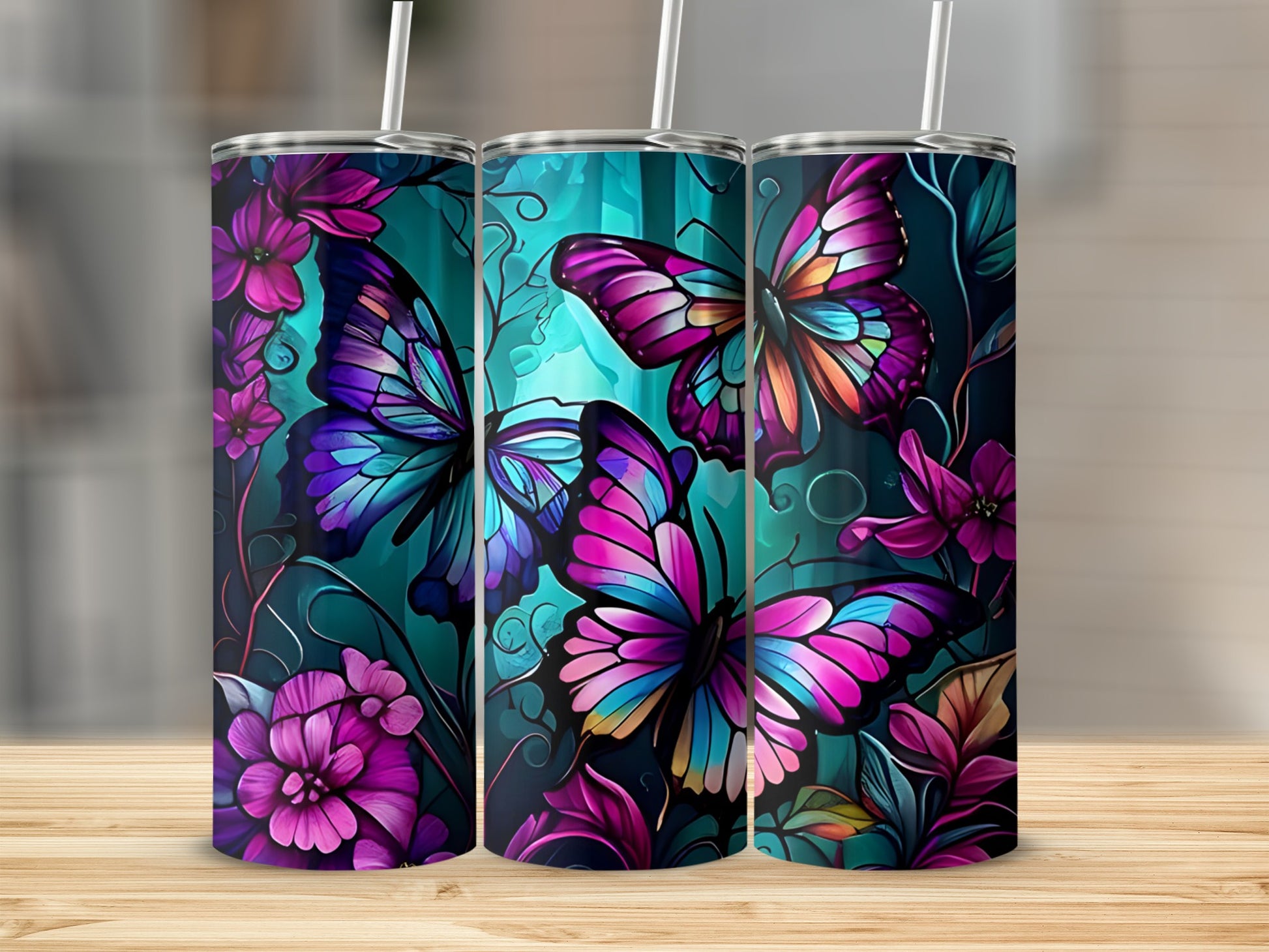 Three tall tumblers with colorful butterfly and floral designs.