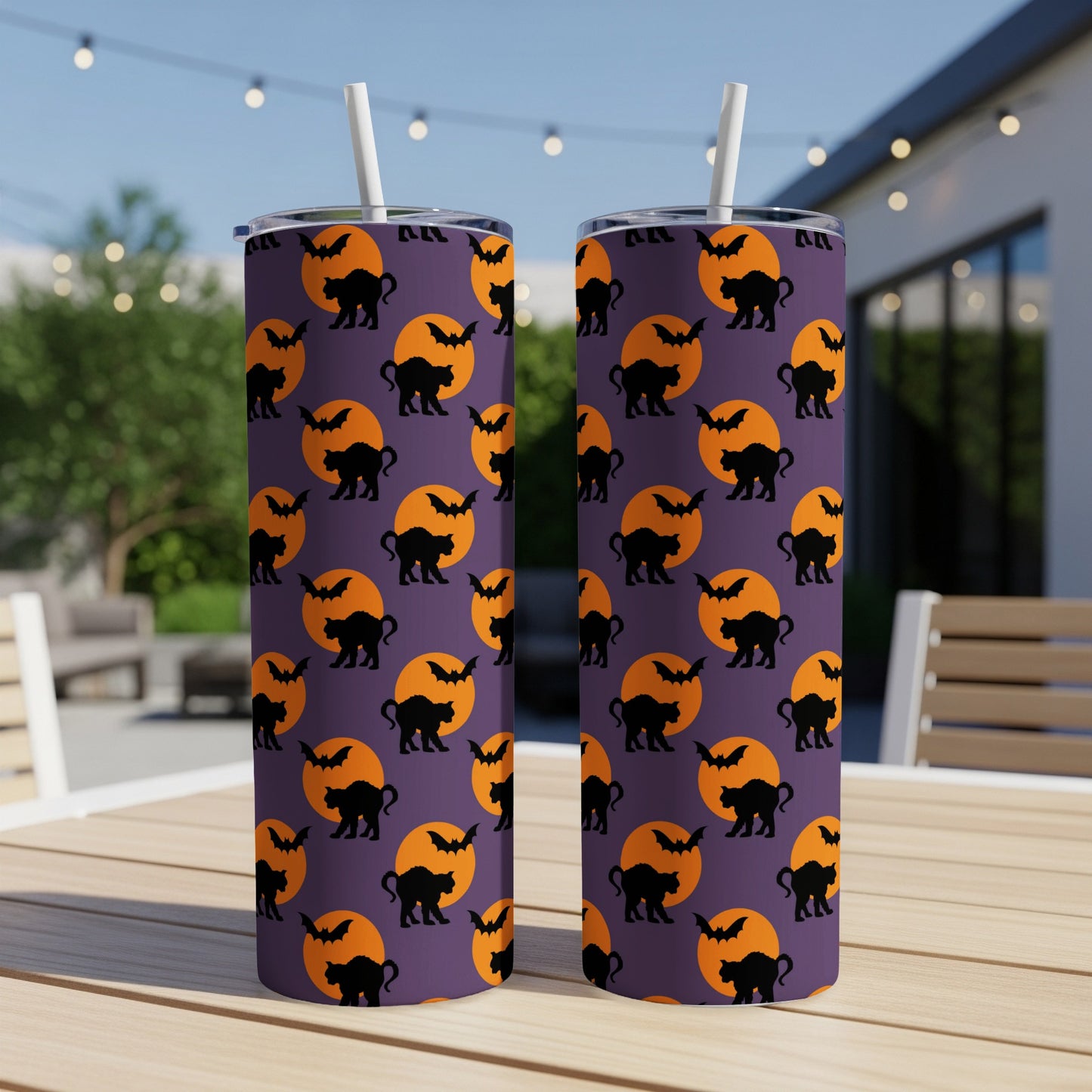 Purple tumbler with Halloween pattern of black cats and bats on orange moons.