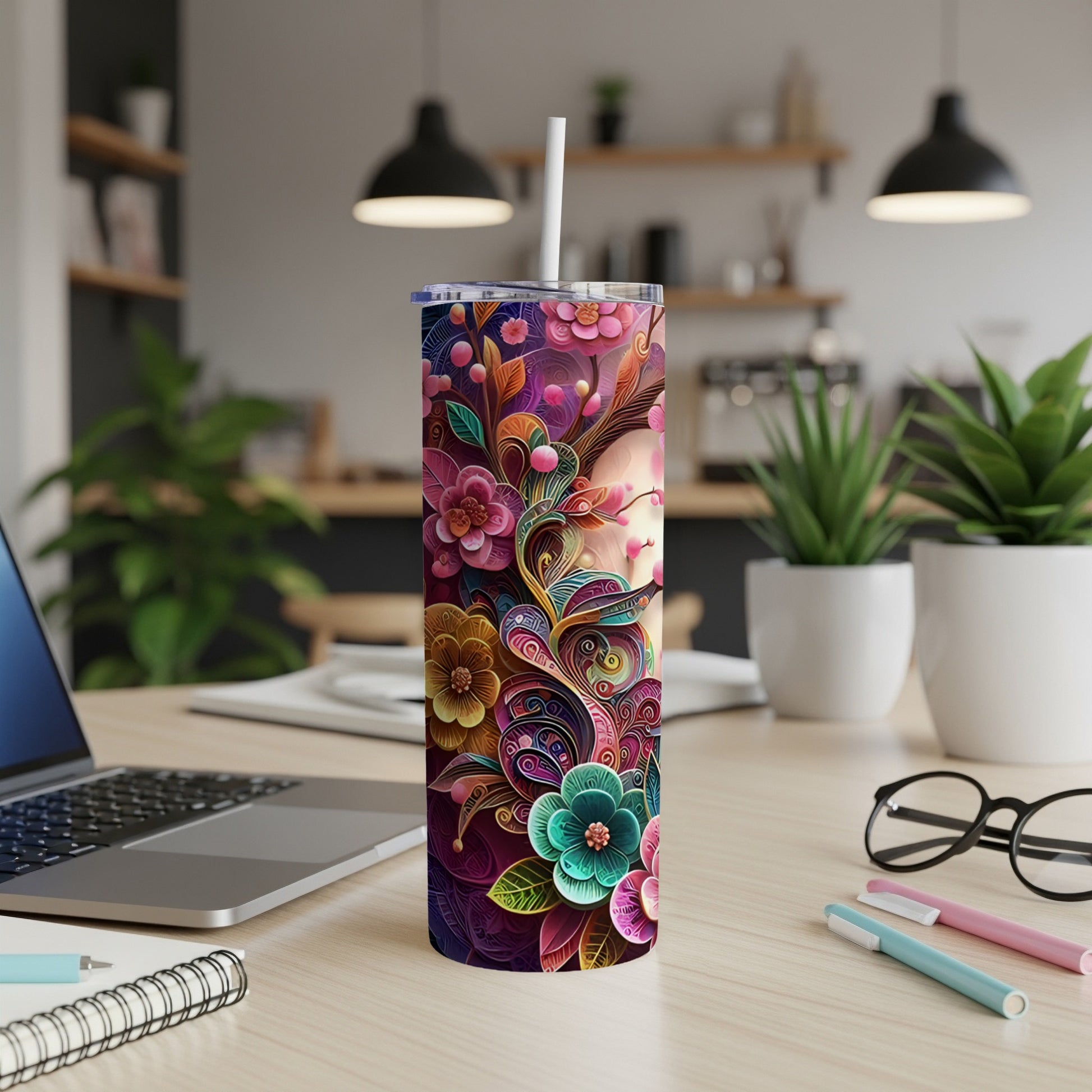 Floral patterned tumbler with a straw on a desk.