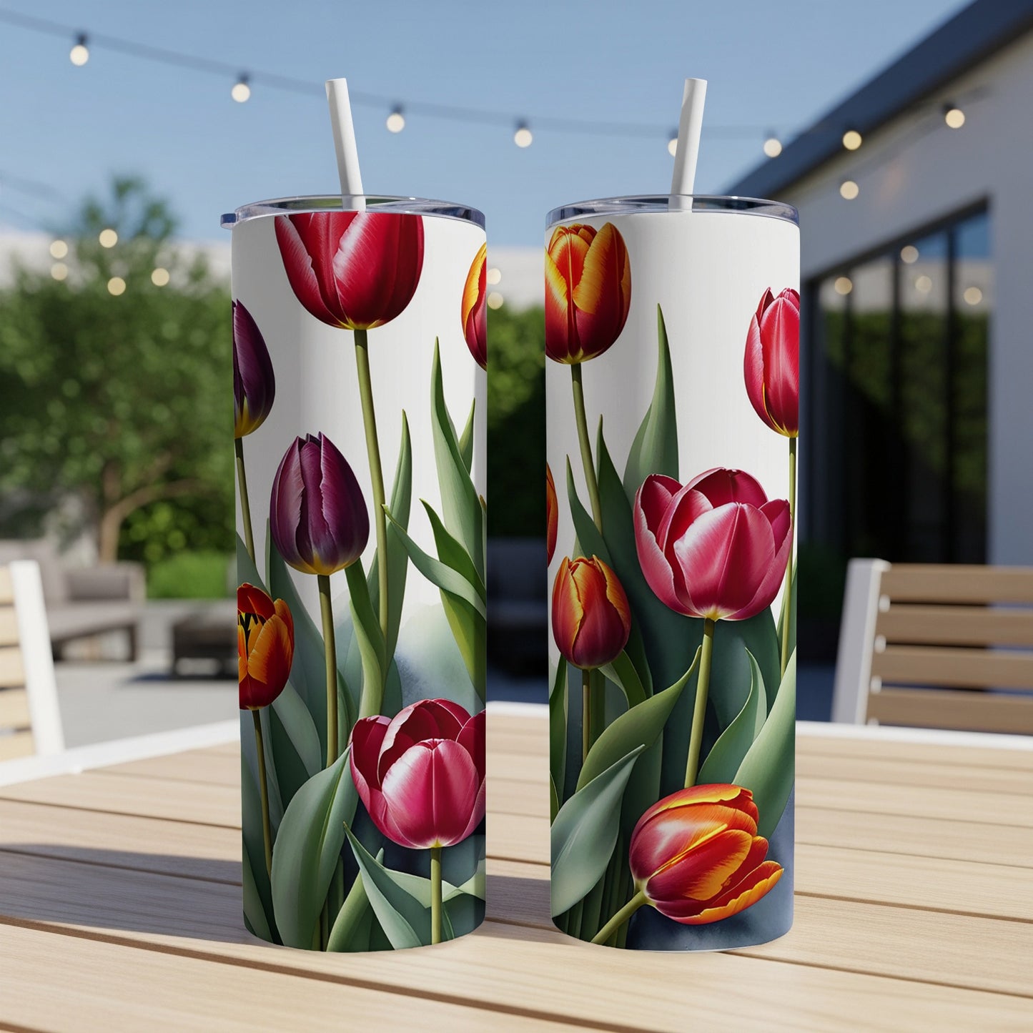 Two tumblers with a floral tulip pattern on a table outdoors.