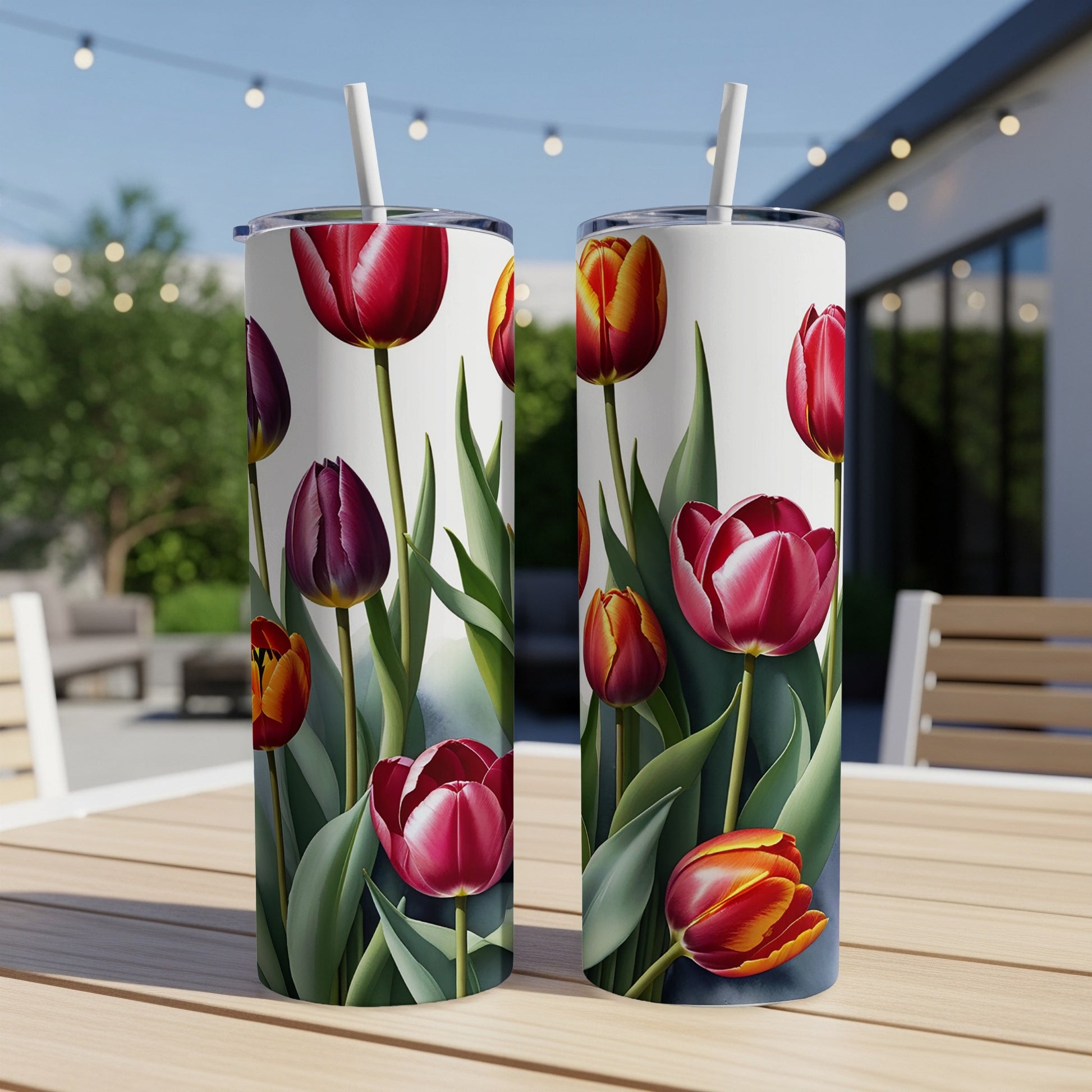 Two tumblers with a floral tulip pattern on a table outdoors.