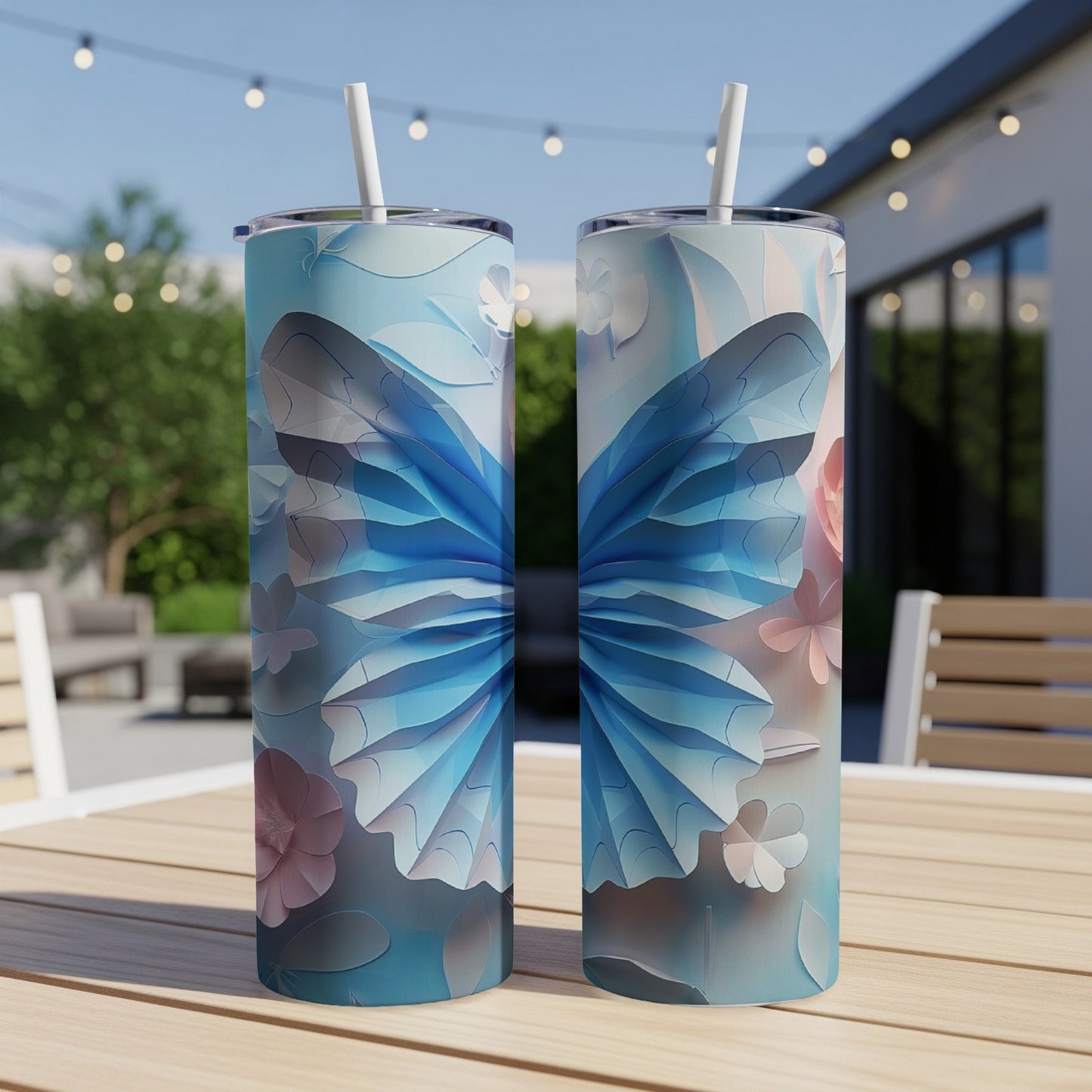 Two blue butterfly tumblers with straws on a wooden table.