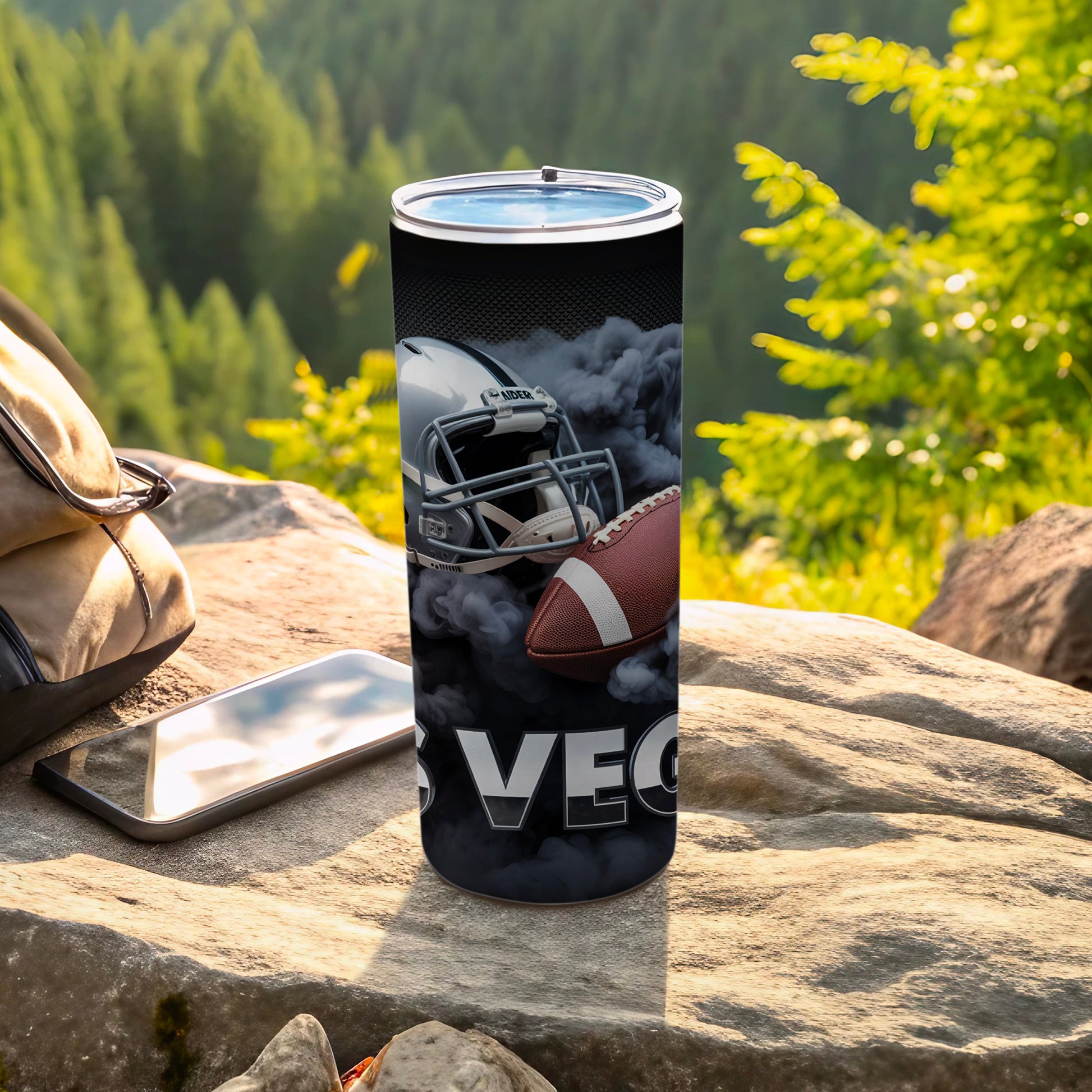 Las Vegas Raiders football helmet and ball on a tumbler with smoke.
