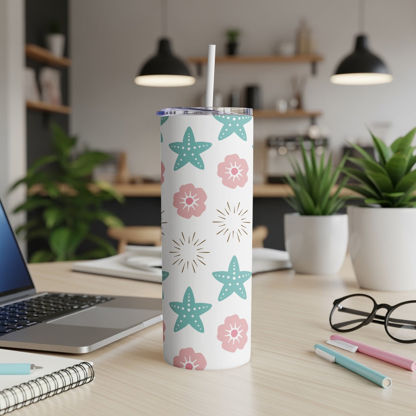 White tumbler with starfish and flower pattern and straw.