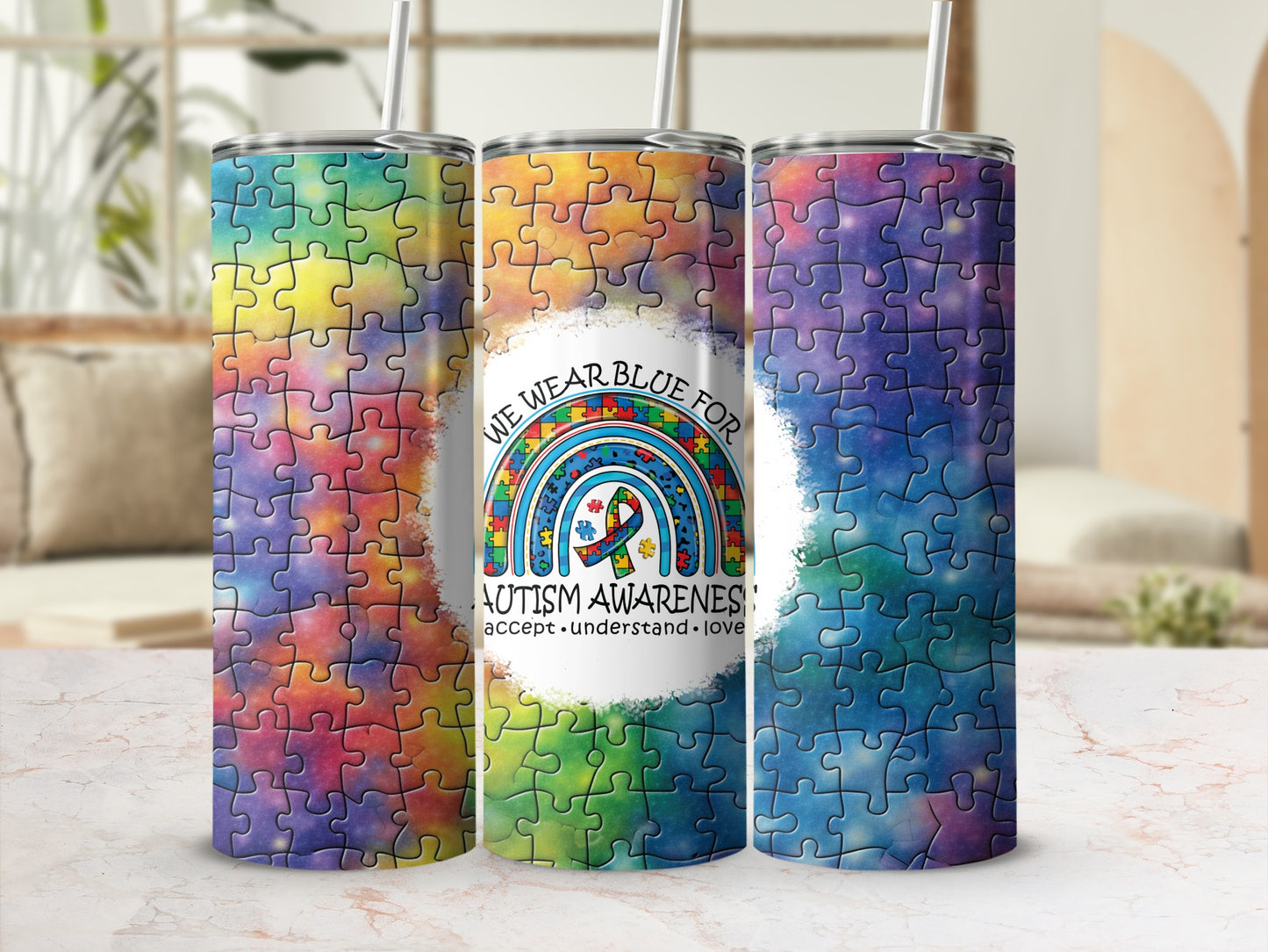 Three tumblers with autism awareness puzzle piece designs and text.