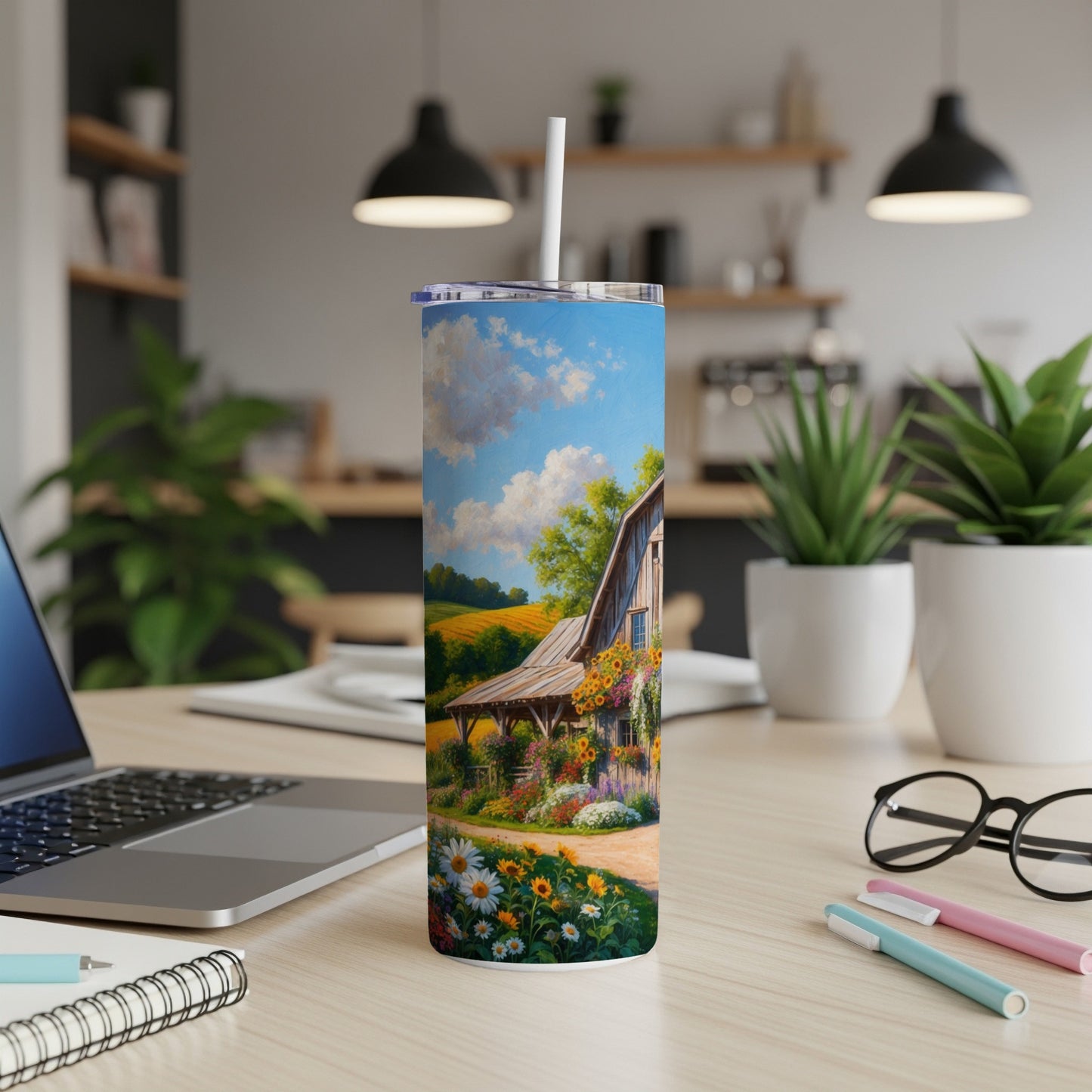 Tumbler with barn and flower field scene on a desk.