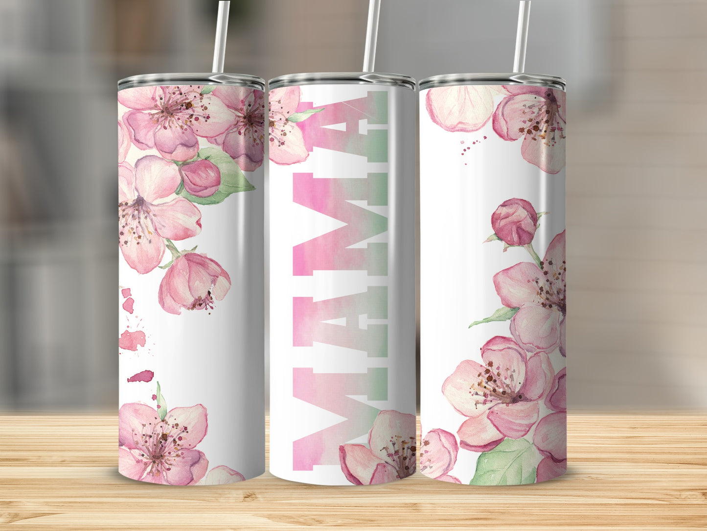 Pink floral Mama tumbler with straw on a wooden surface.