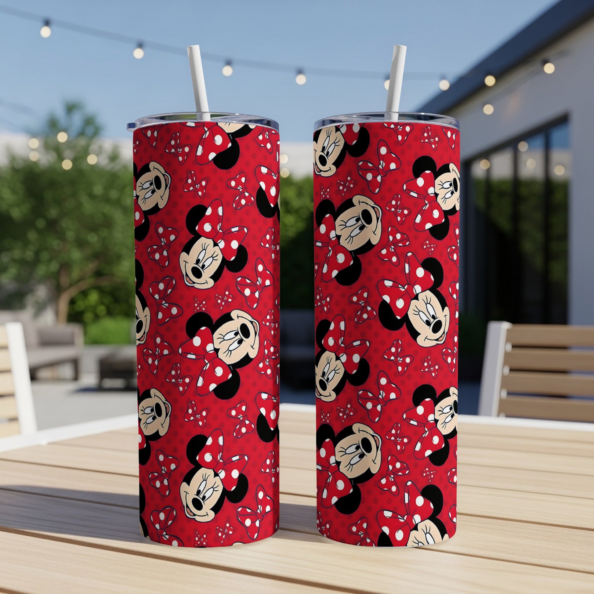 Two Minnie Mouse patterned tumblers with red bows and polka dots on a table.