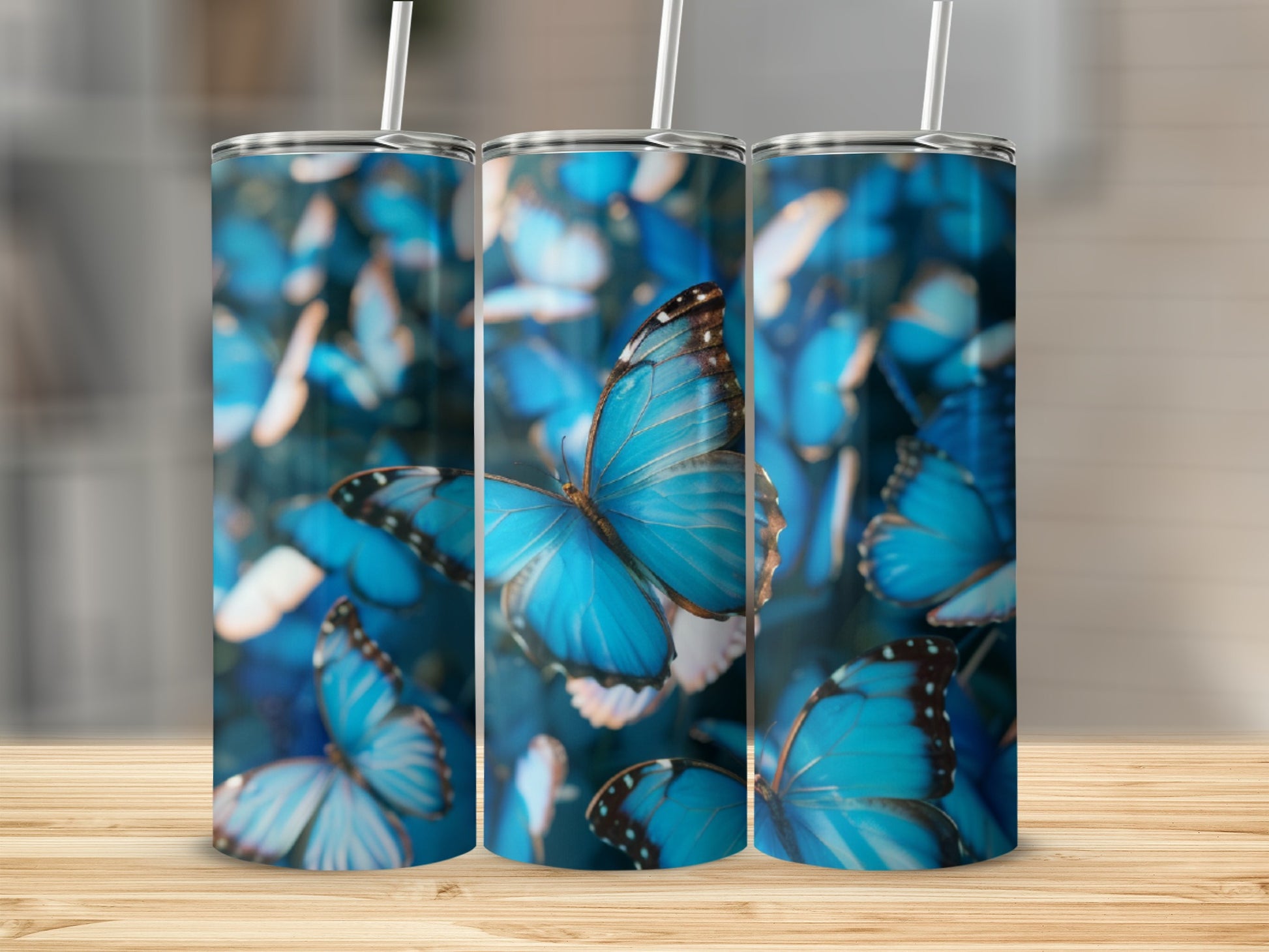 Three tumblers with a close-up of vibrant blue butterflies on a bokeh background.