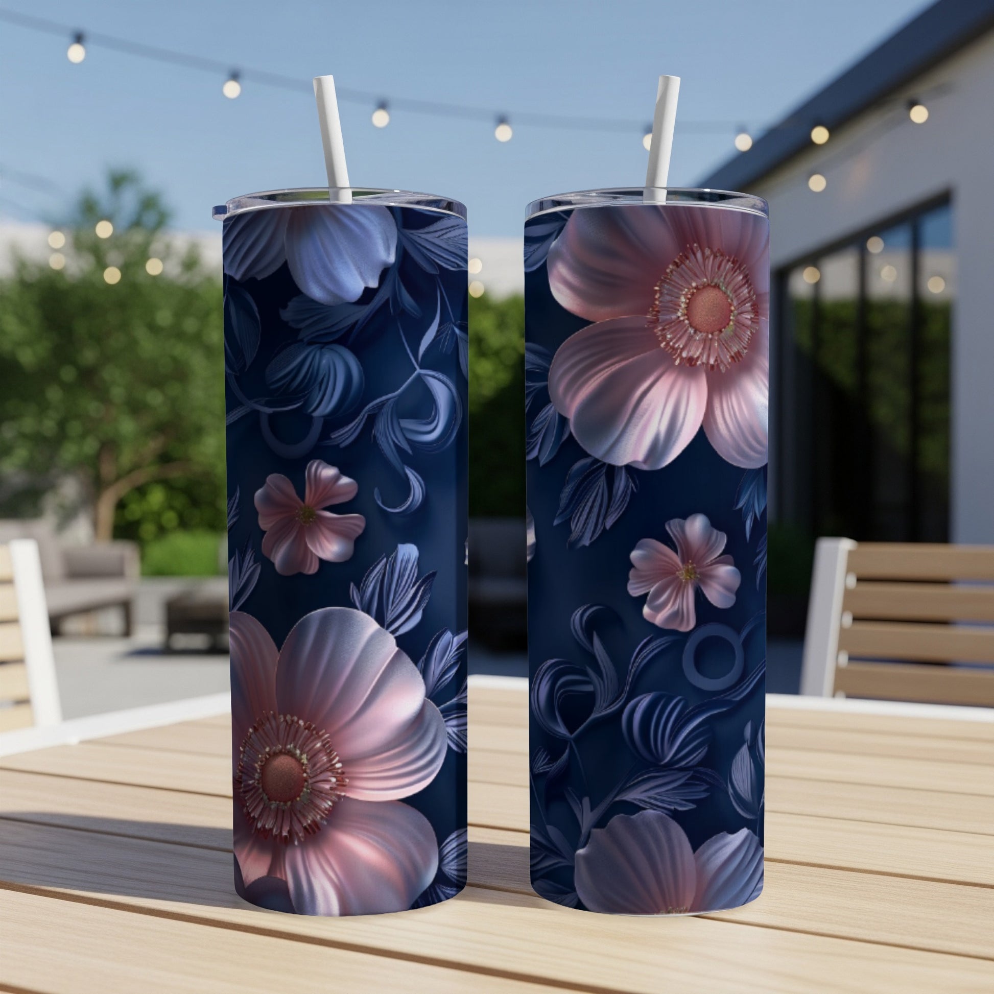 Two dark blue tumblers with pink and blue floral patterns on a wooden table.