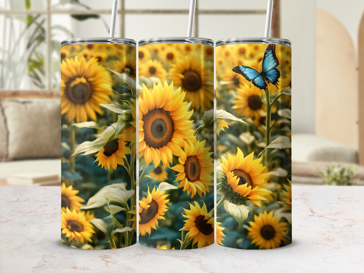 Three tumblers with sunflower and butterfly pattern on a white marble surface.