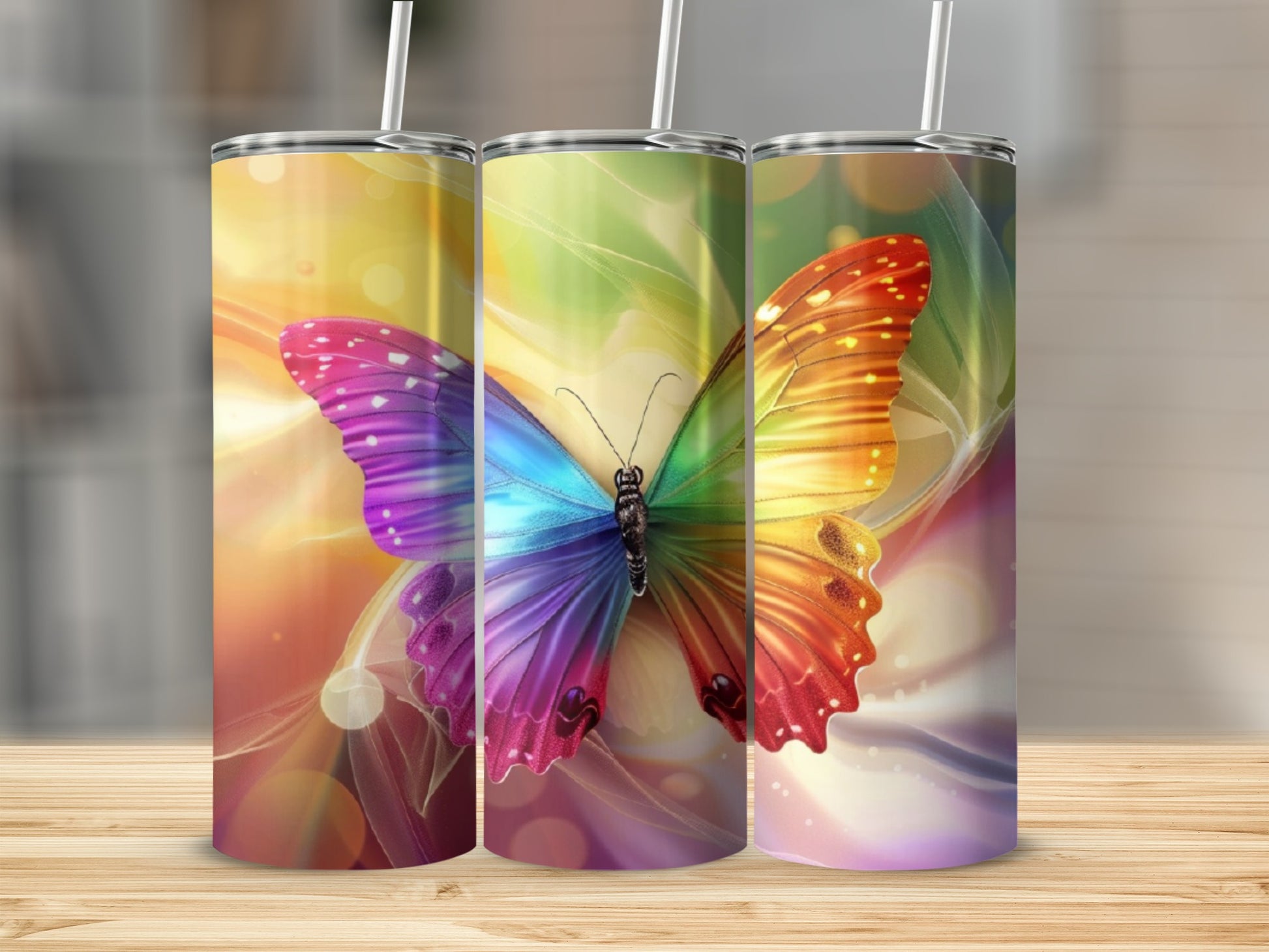 Three tumblers with a vibrant, multi-colored butterfly design and light flares.