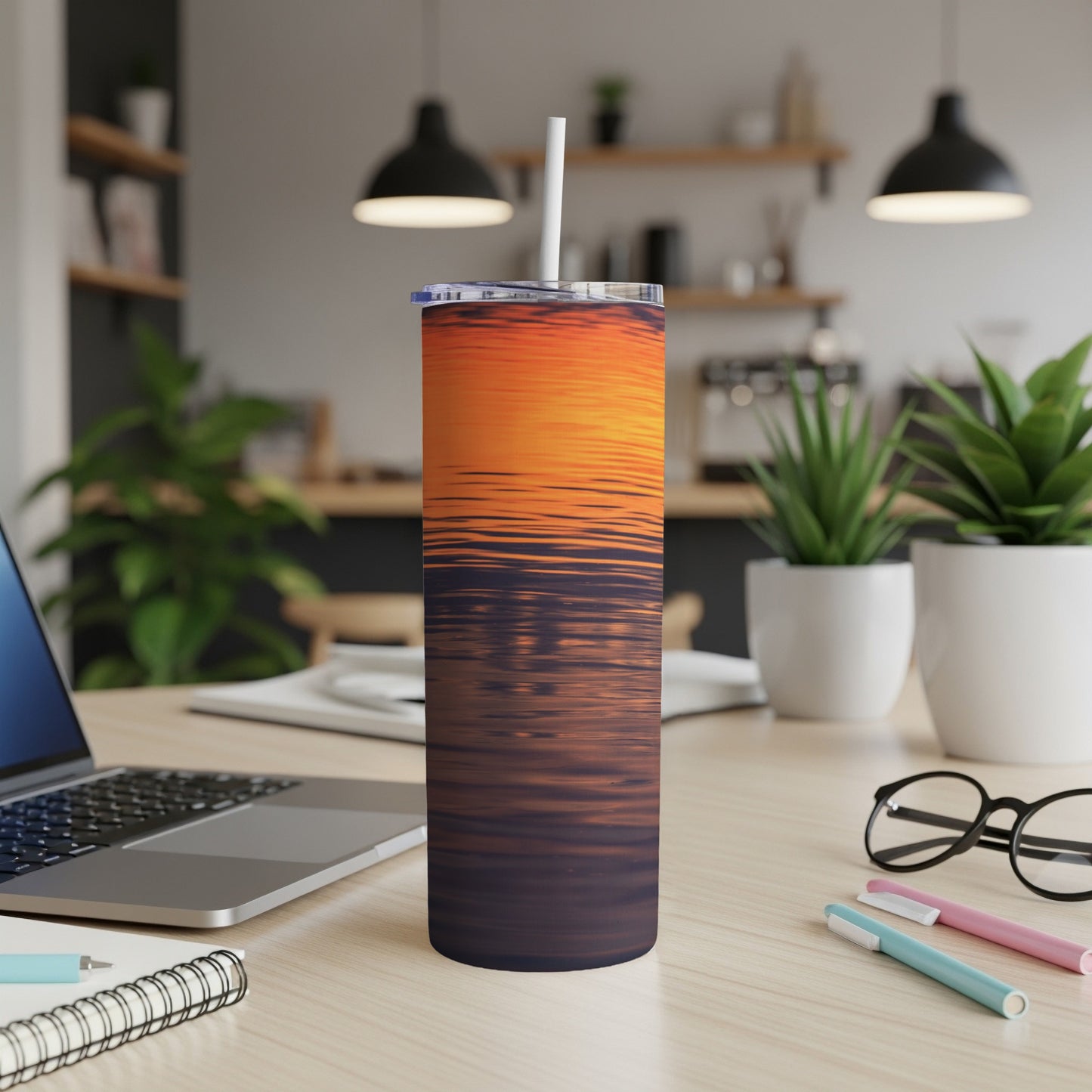 Sunset reflection on a stainless steel tumbler with straw.