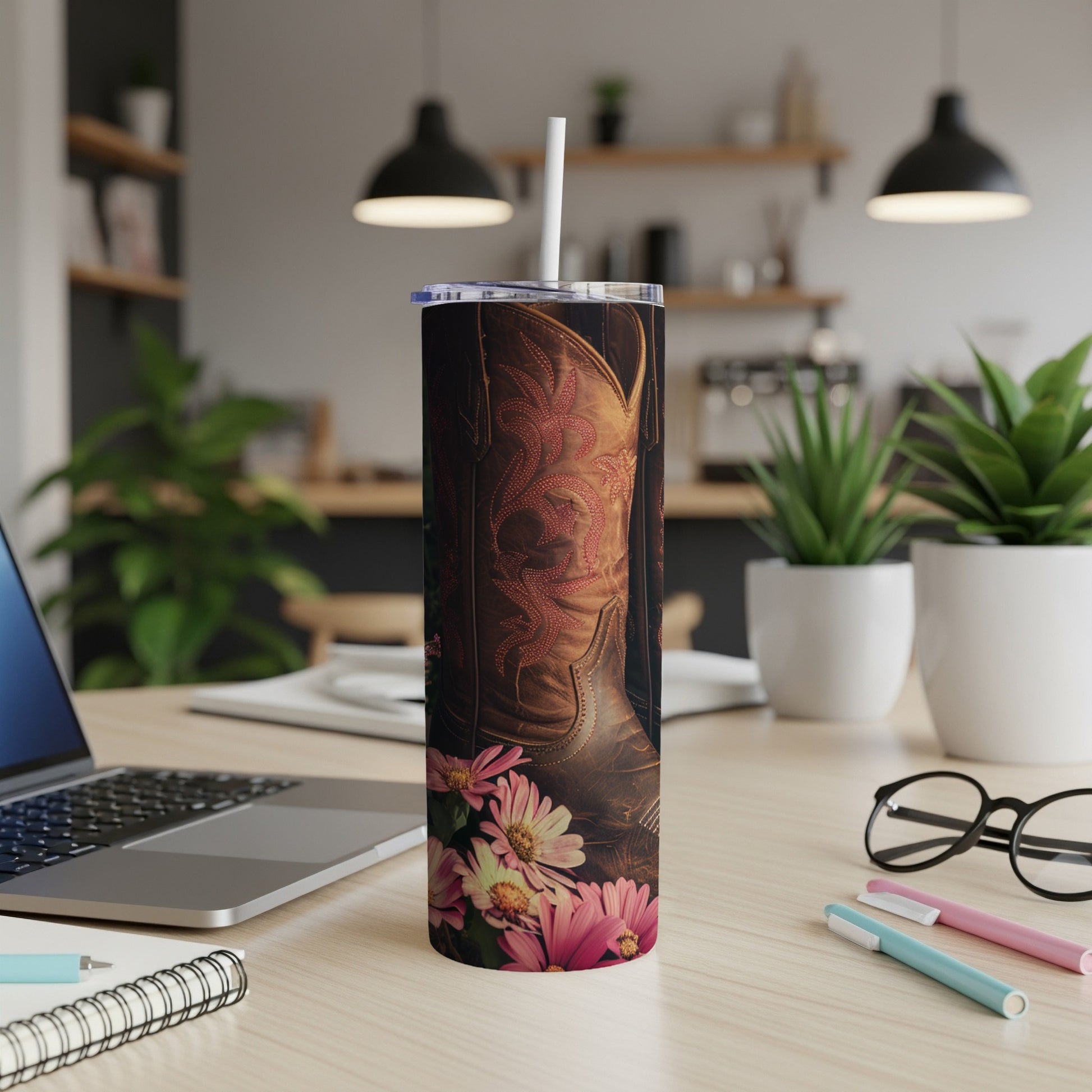 Brown leather cowboy boot with floral pattern on a tumbler with straw.