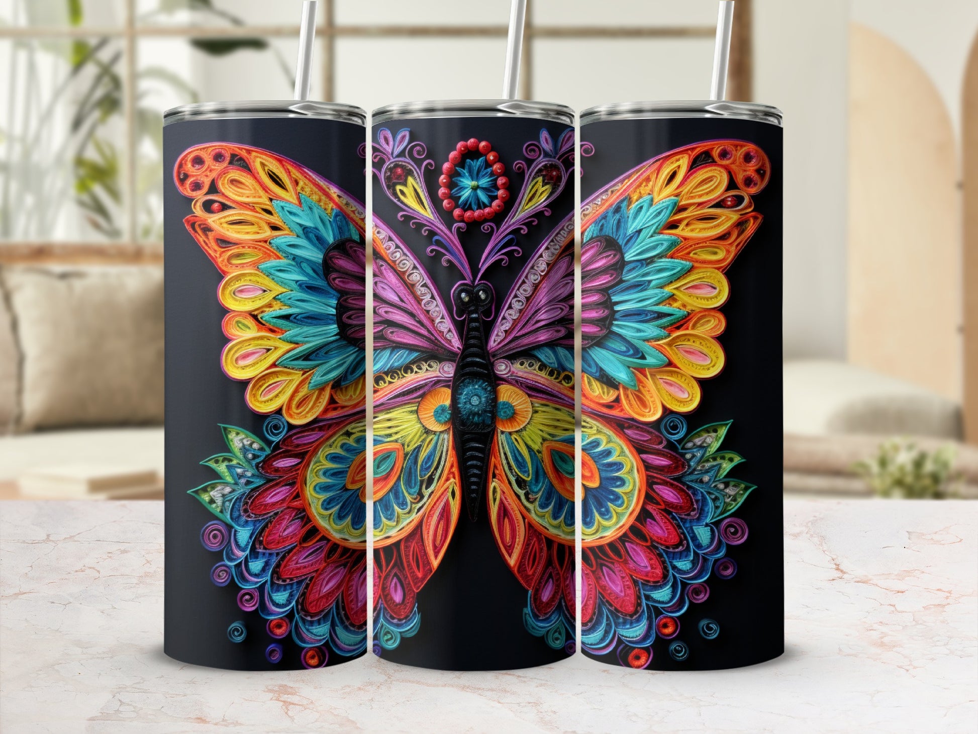 Three black tumblers with colorful ornate butterfly designs, each with a straw.