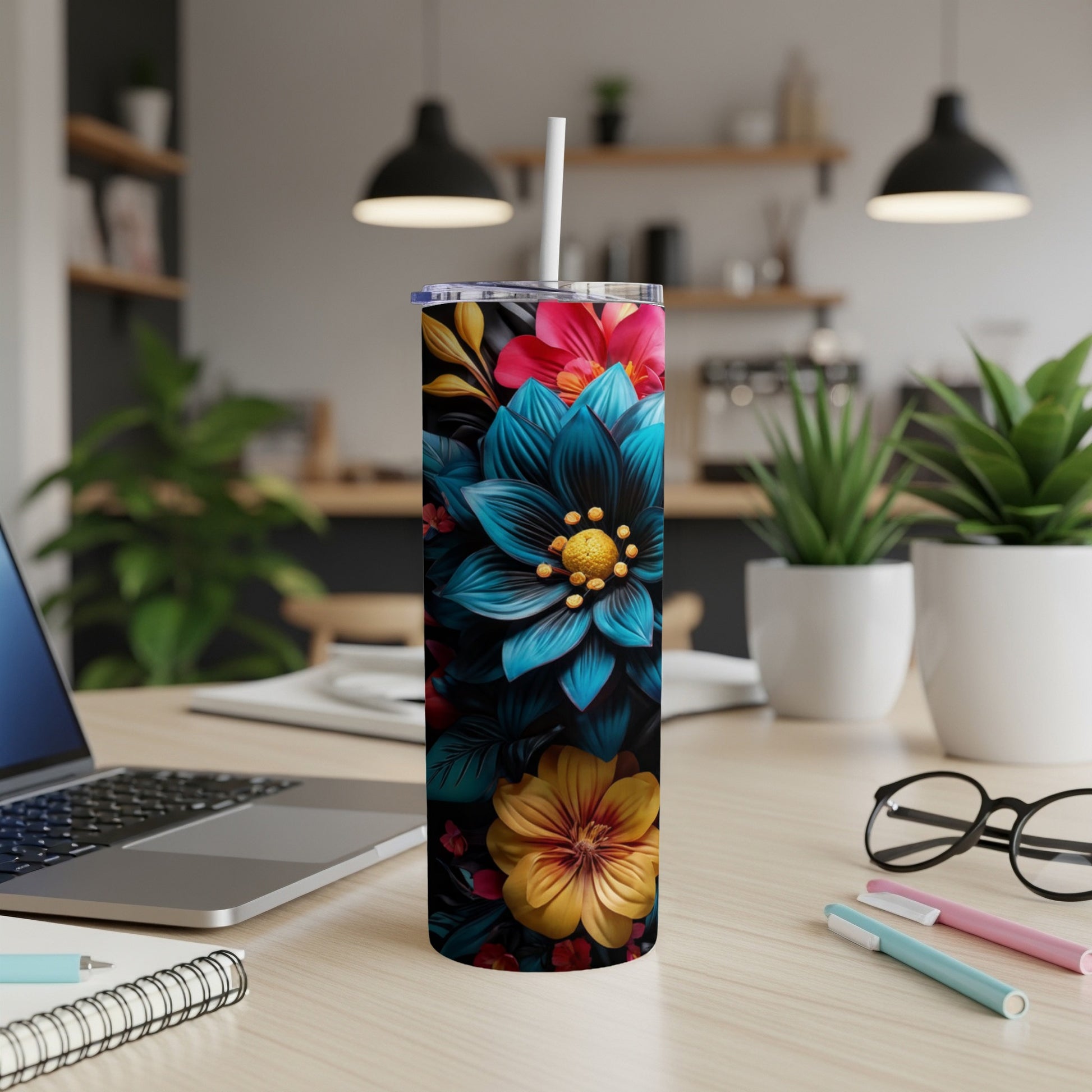 Tumbler with blue, yellow, and pink floral design on a desk.