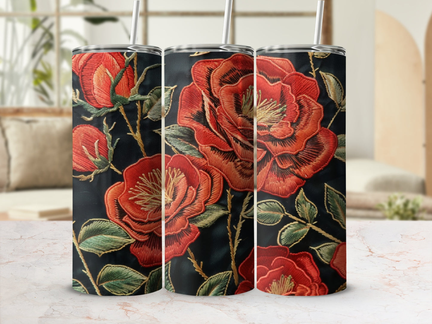 Three tumblers with red embroidered floral designs on a dark background.