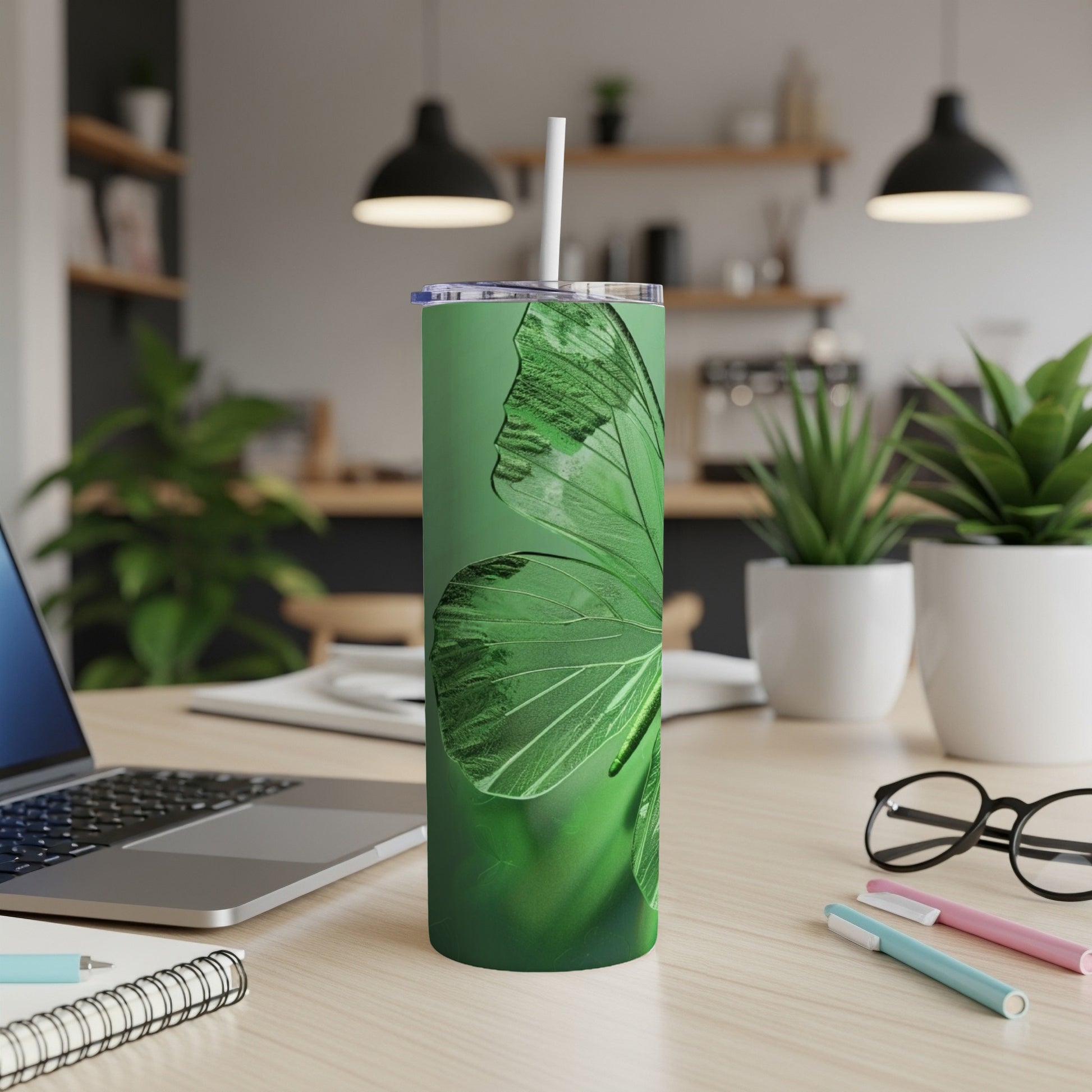 Green butterfly wings design on a tall, slim tumbler with a straw.