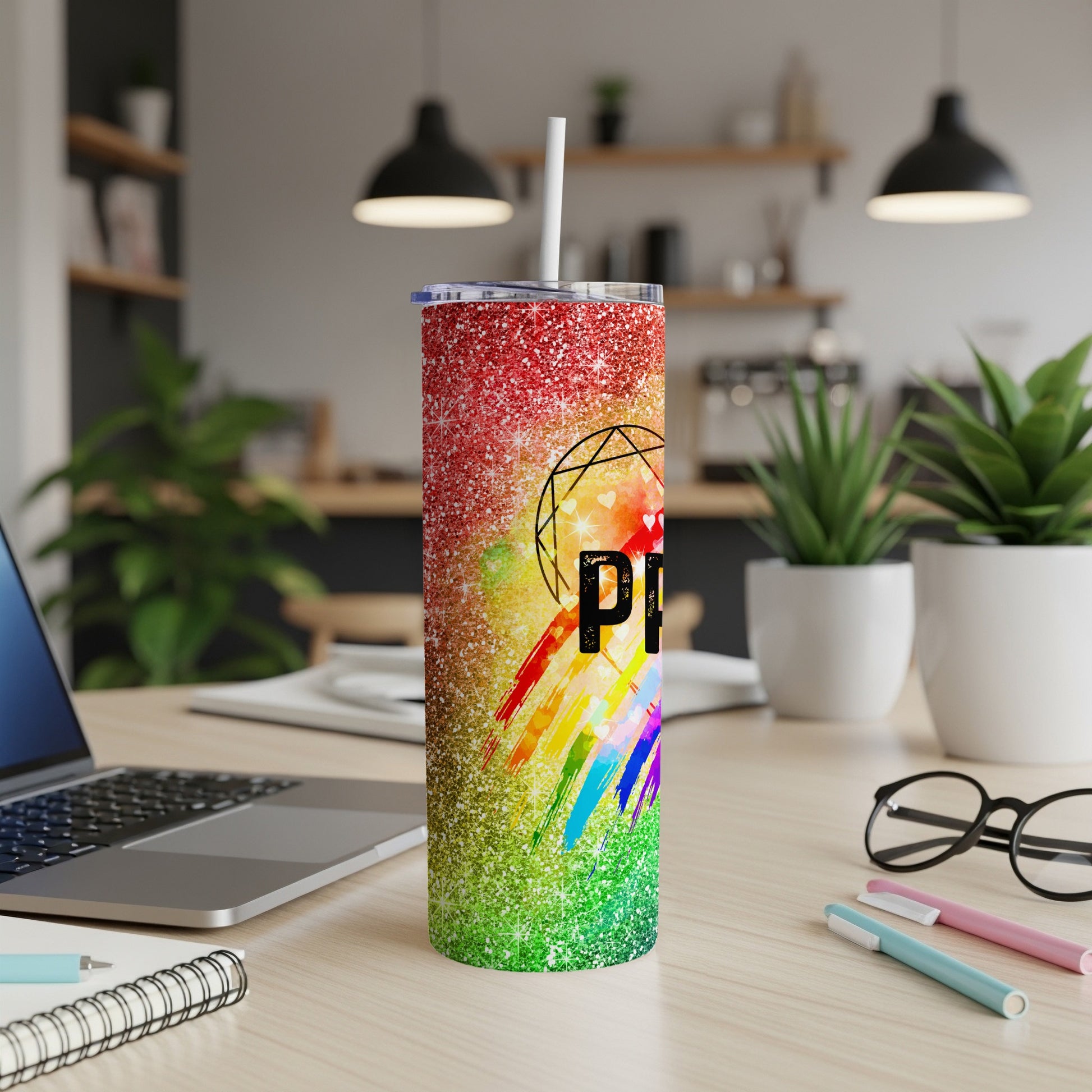 Glittery tumbler with rainbow stripes and "Pride" text on a desk.