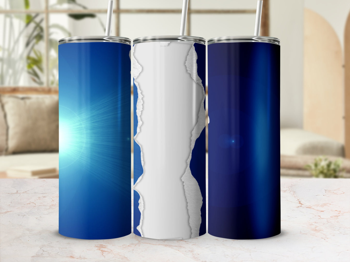 Three blue tumblers with ripped paper effect on a marble surface.