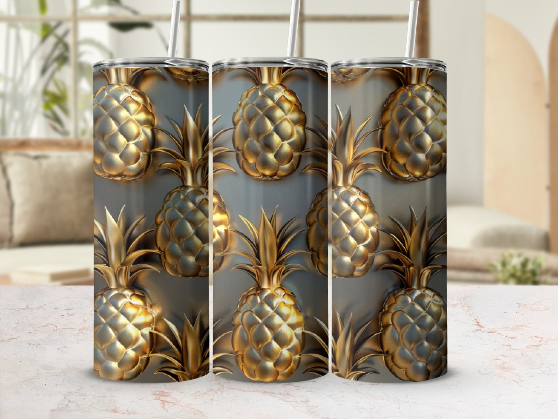 Three gold pineapple tumblers with straws on a marble countertop.