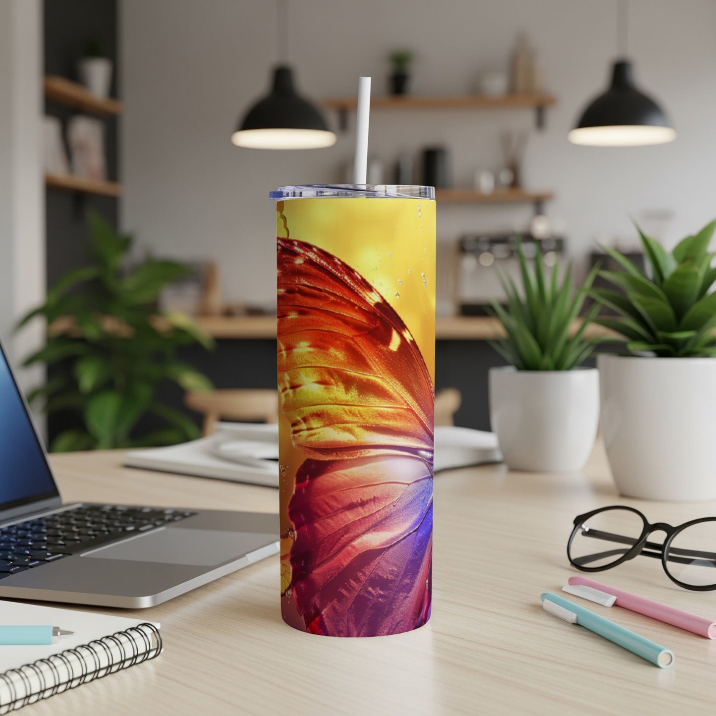 Tumbler with a vibrant butterfly wing design, featuring a straw.