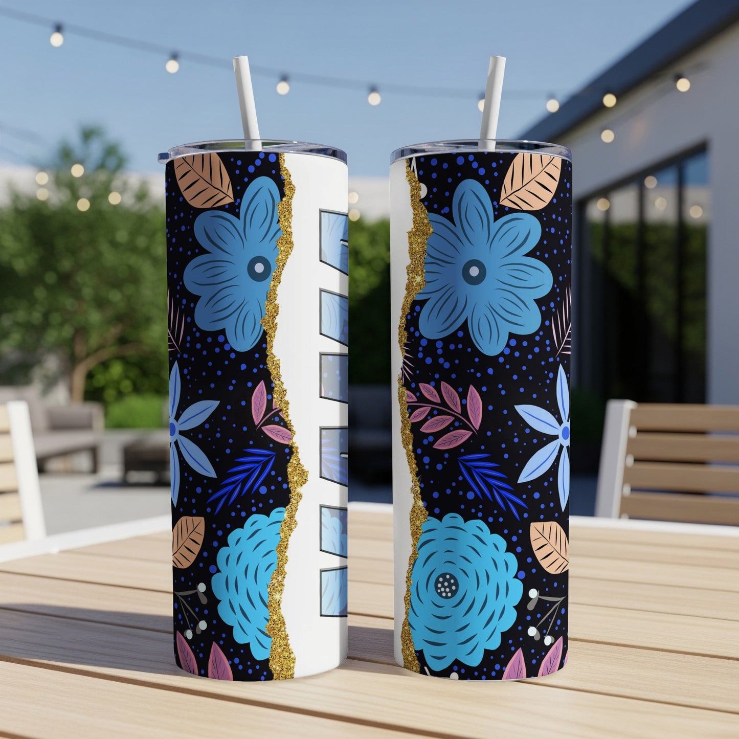 Two tumblers with blue floral design and white text on a wooden table.