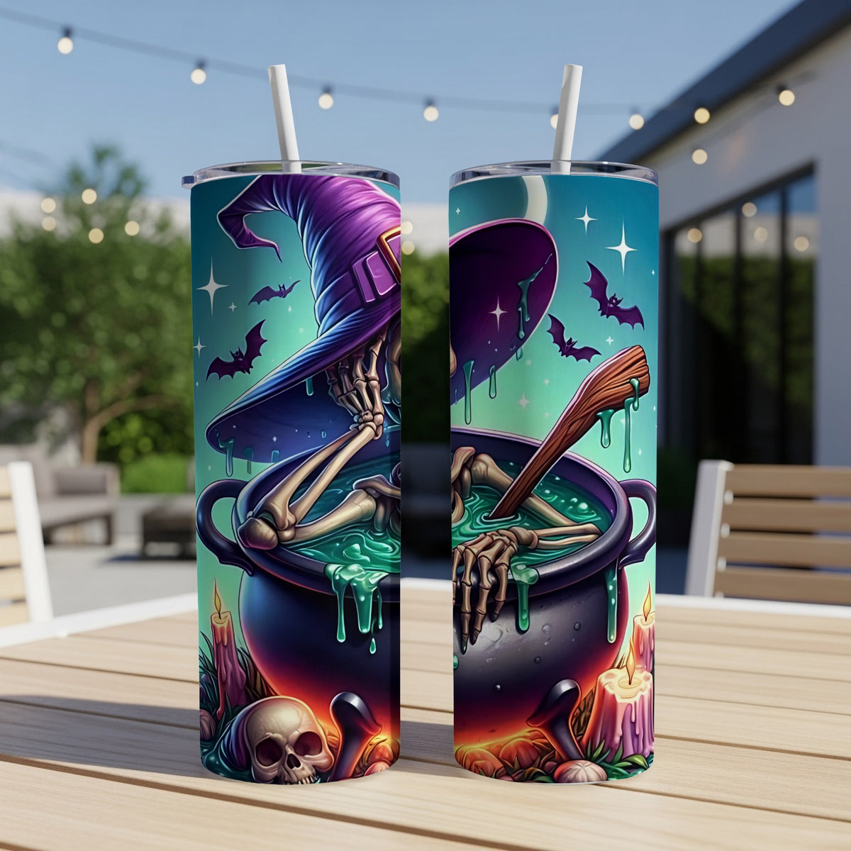 Two Halloween-themed tumblers with skeleton and witch hat designs sit on a table.