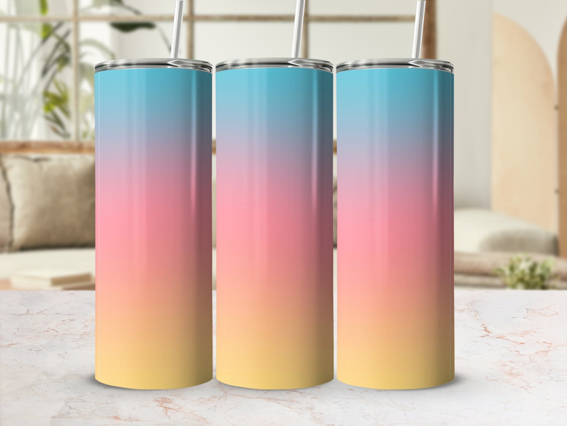 Three tumblers with a sunset gradient color design on a marble surface.