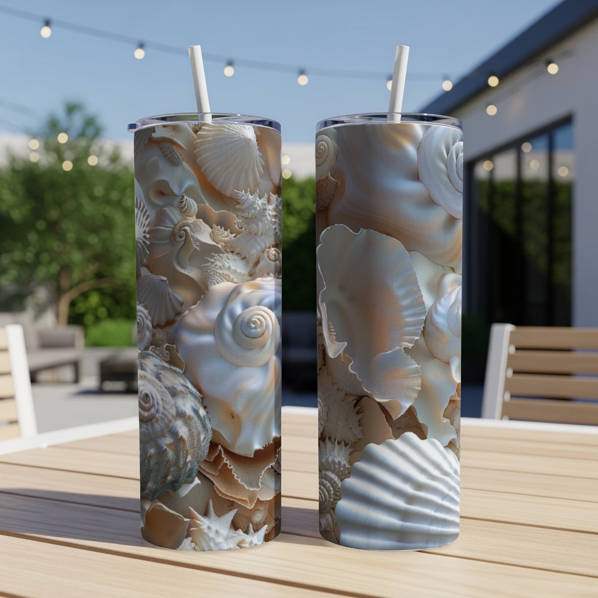 Two tumblers with intricate seashell patterns on a table outdoors.