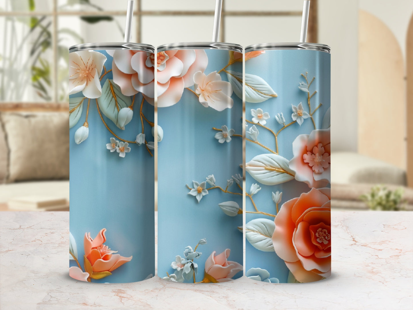 Three blue tumblers with floral designs and white straws.