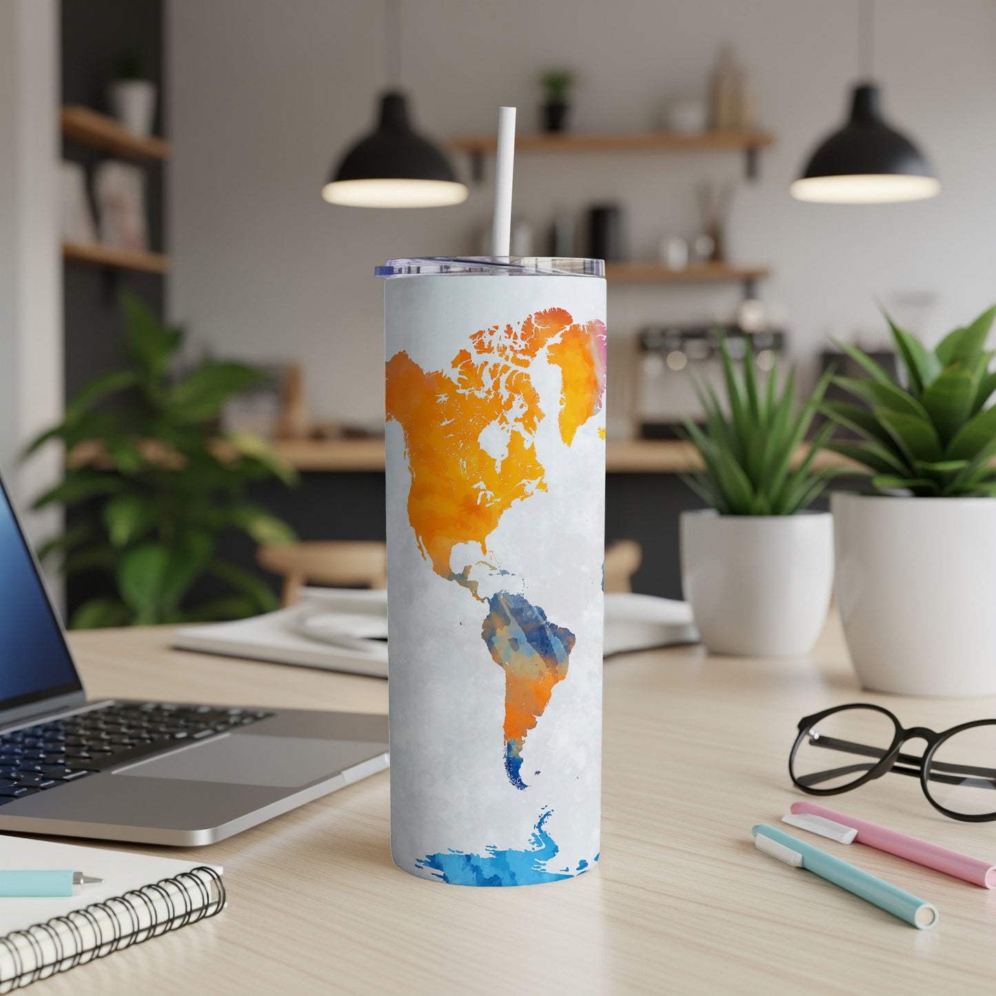 White tumbler with a watercolor map of North and South America in orange and blue.