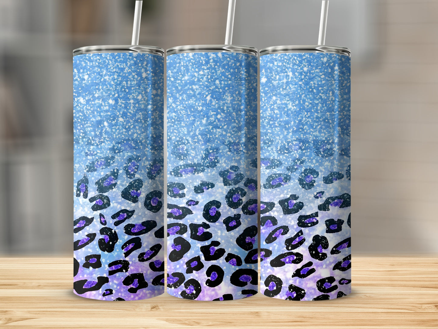 Three tall tumblers with blue glitter and purple leopard print.
