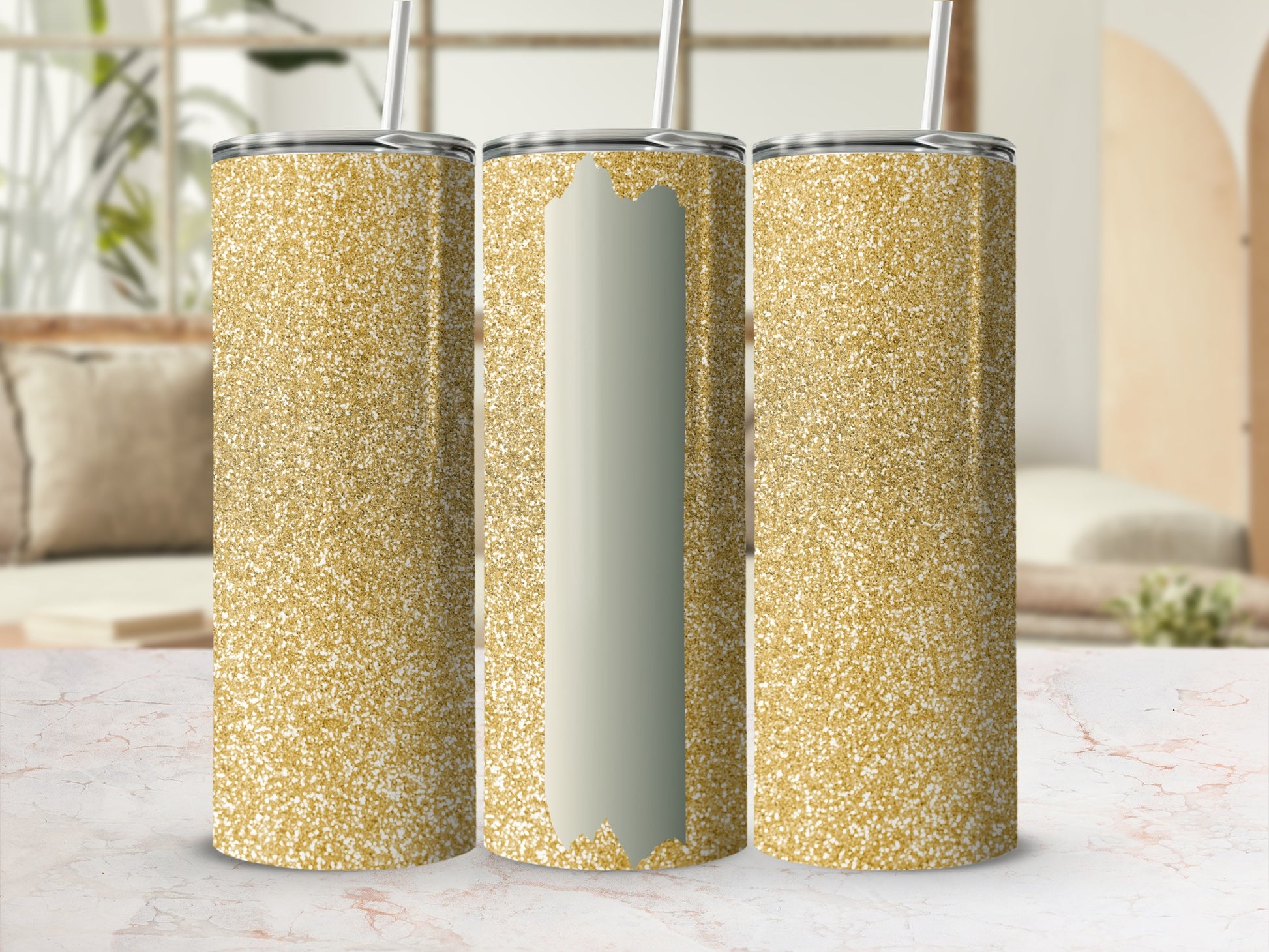 Three glittery gold tumblers with straws on a marble countertop.