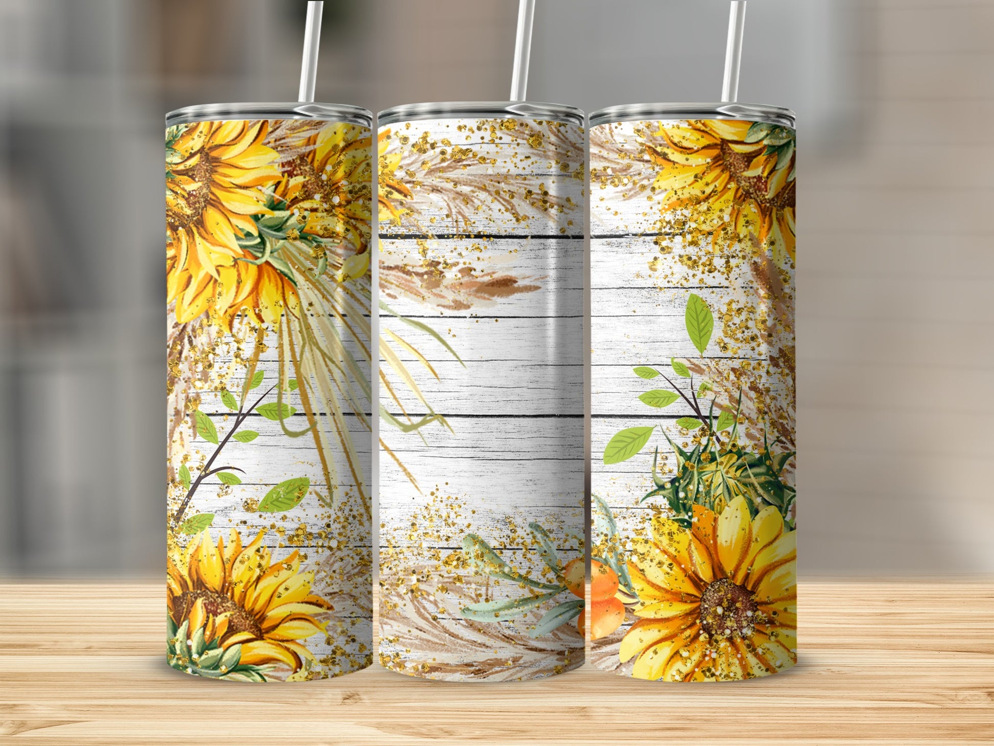 Three tumblers with sunflowers and dried grass design on wood background.