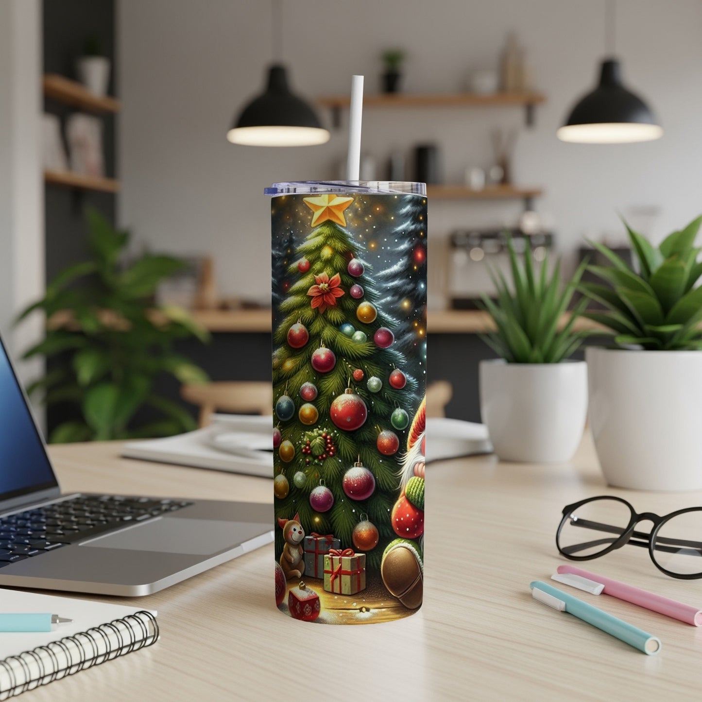 Christmas tumbler with Santa and tree, on a wooden desk with laptop.