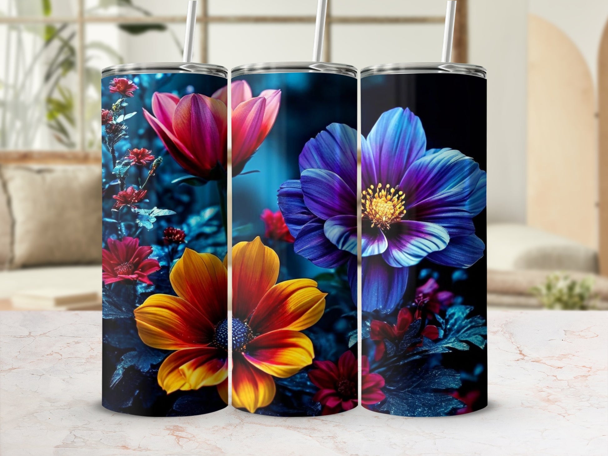Three tumblers with vibrant floral designs: a pink tulip, a blue and yellow dahlia, and red flowers.