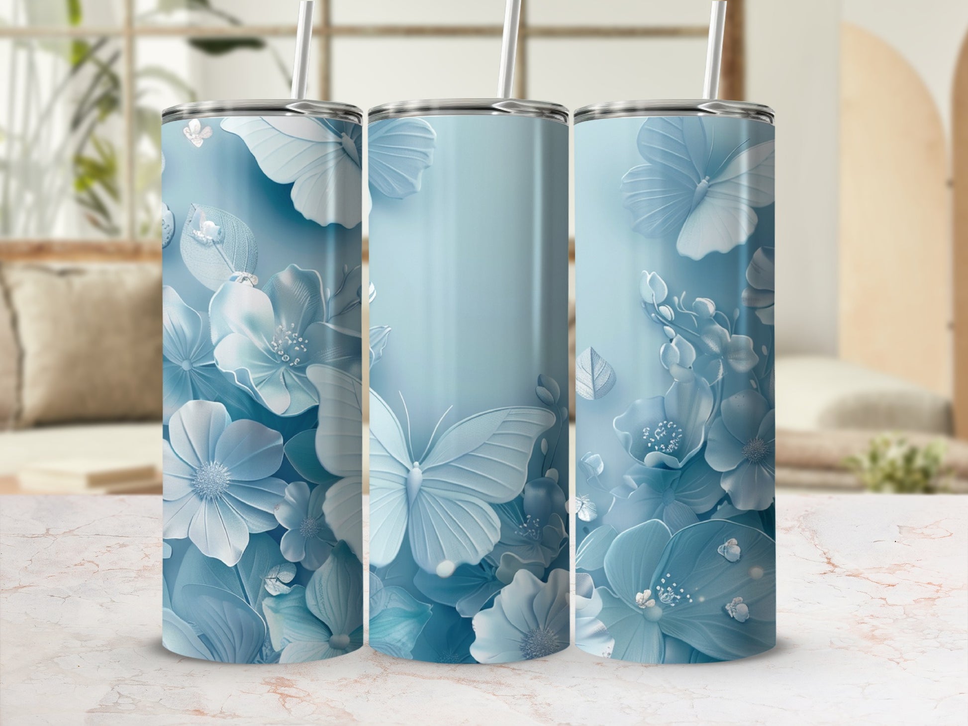 Blue floral butterfly pattern tumbler with straw on marble surface.
